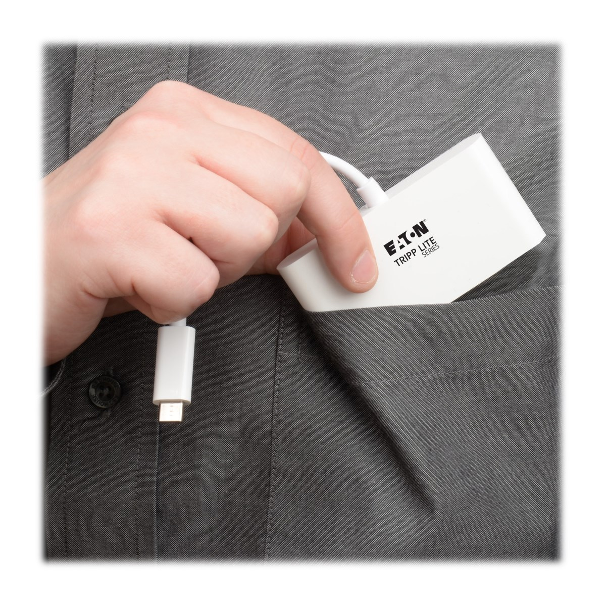 Una mano che mette un adattatore USB bianco in una tasca della camicia, primo piano.