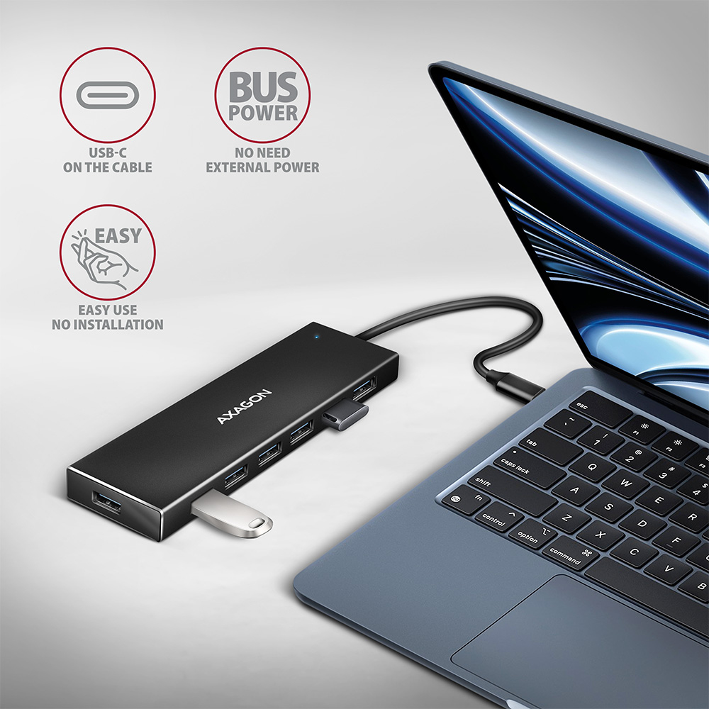 Hub USB-C Axagon nero collegato a un laptop su sfondo bianco.