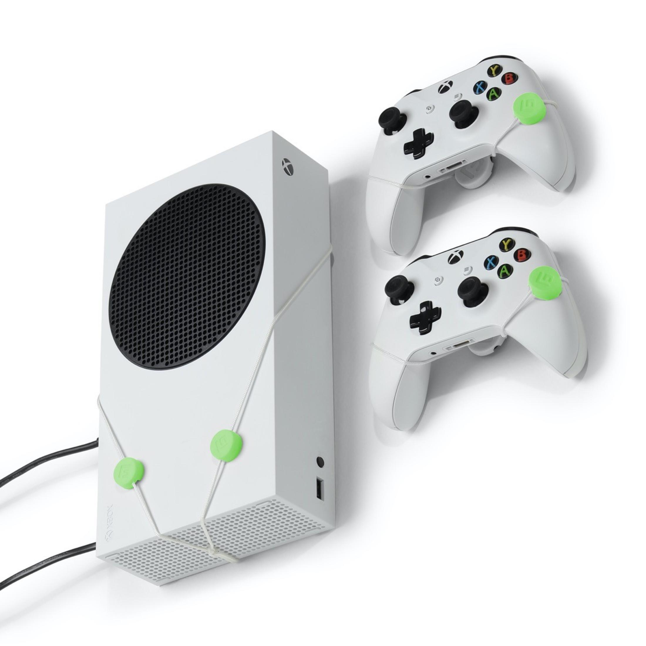 Weiße Xbox Series S Konsole mit zwei weißen Controllern, mit grünen Bändern gesichert.