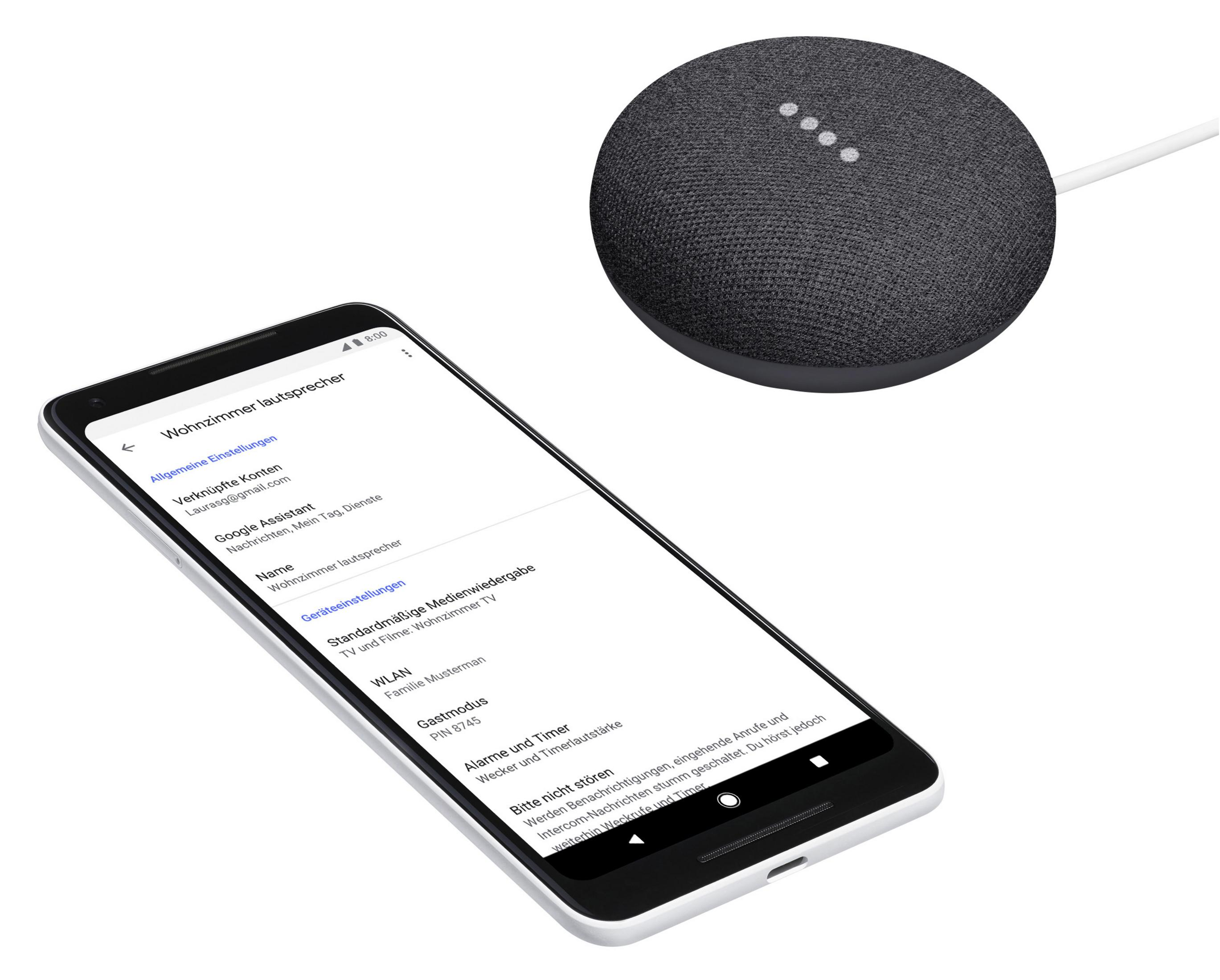 Smartphone mit Einstellungen neben einem Google Home Mini-Lautsprecher auf weißem Untergrund.