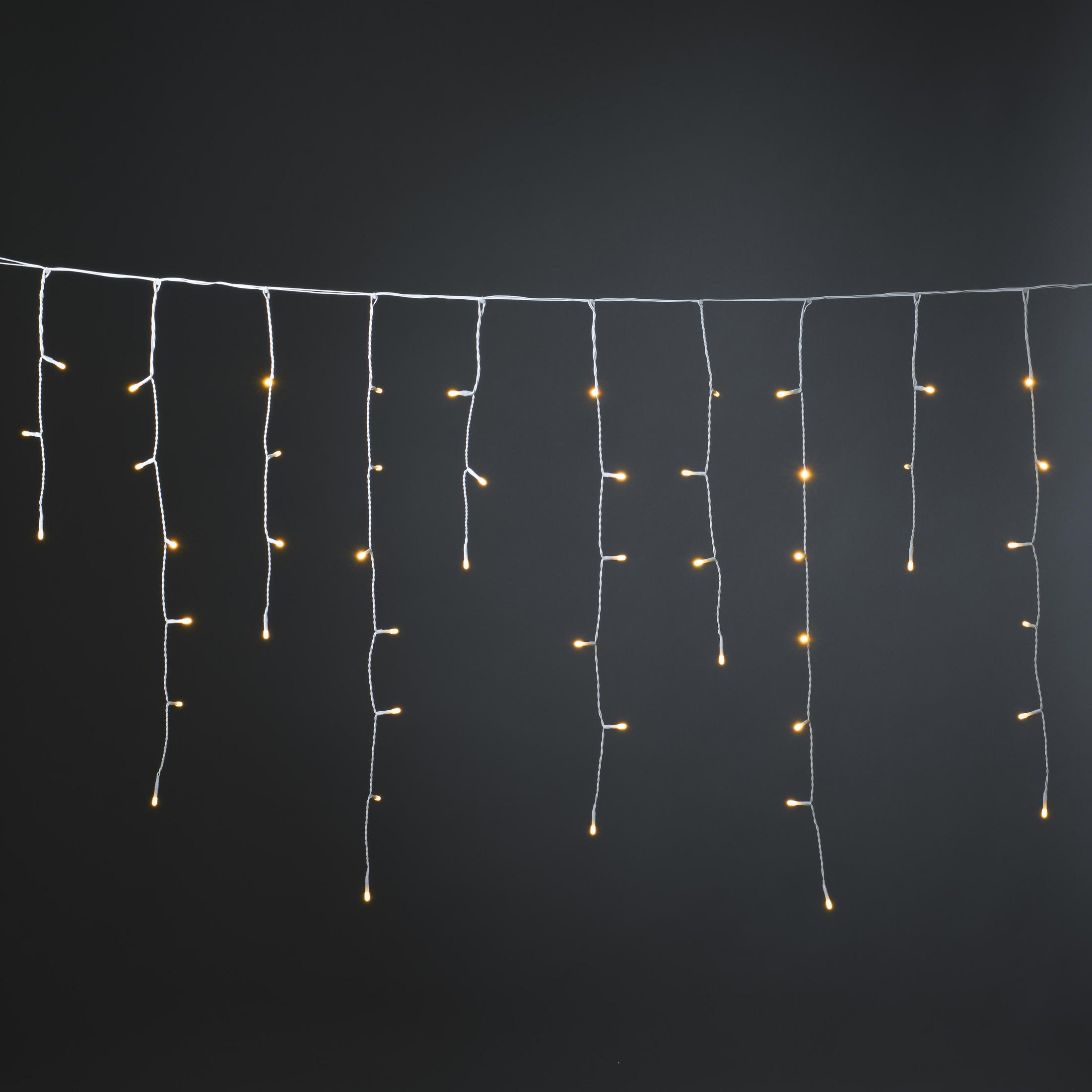 Lichterkette mit LED-Leuchten, die vor schwarzem Hintergrund hängen. Die Lichter sind warmweiß und gleichmäßig verteilt.