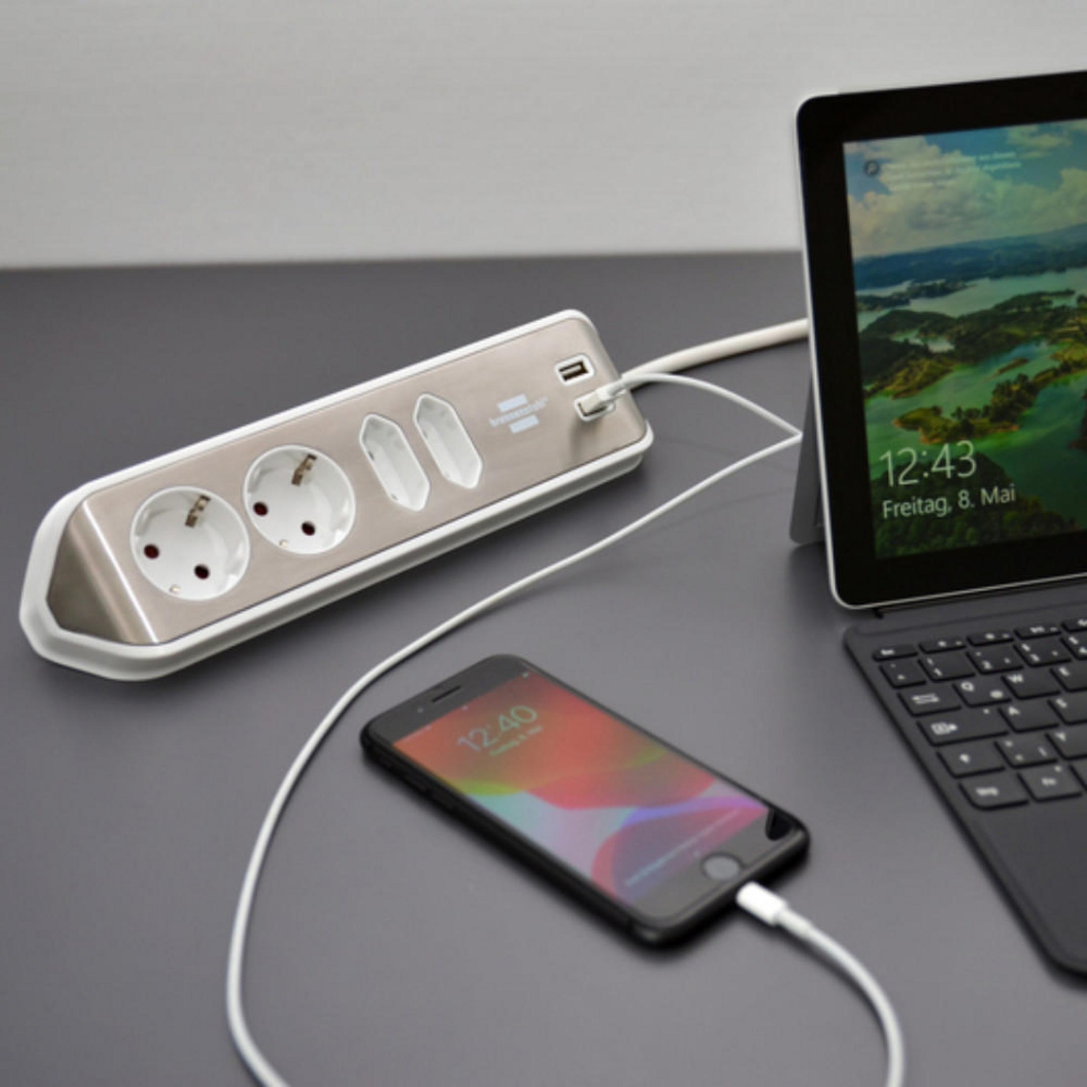Steckdosenleiste mit Steckdosen, USB-Anschlüssen und Telefonladung. Tablet auf dem Schreibtisch. Weißes Kabel.