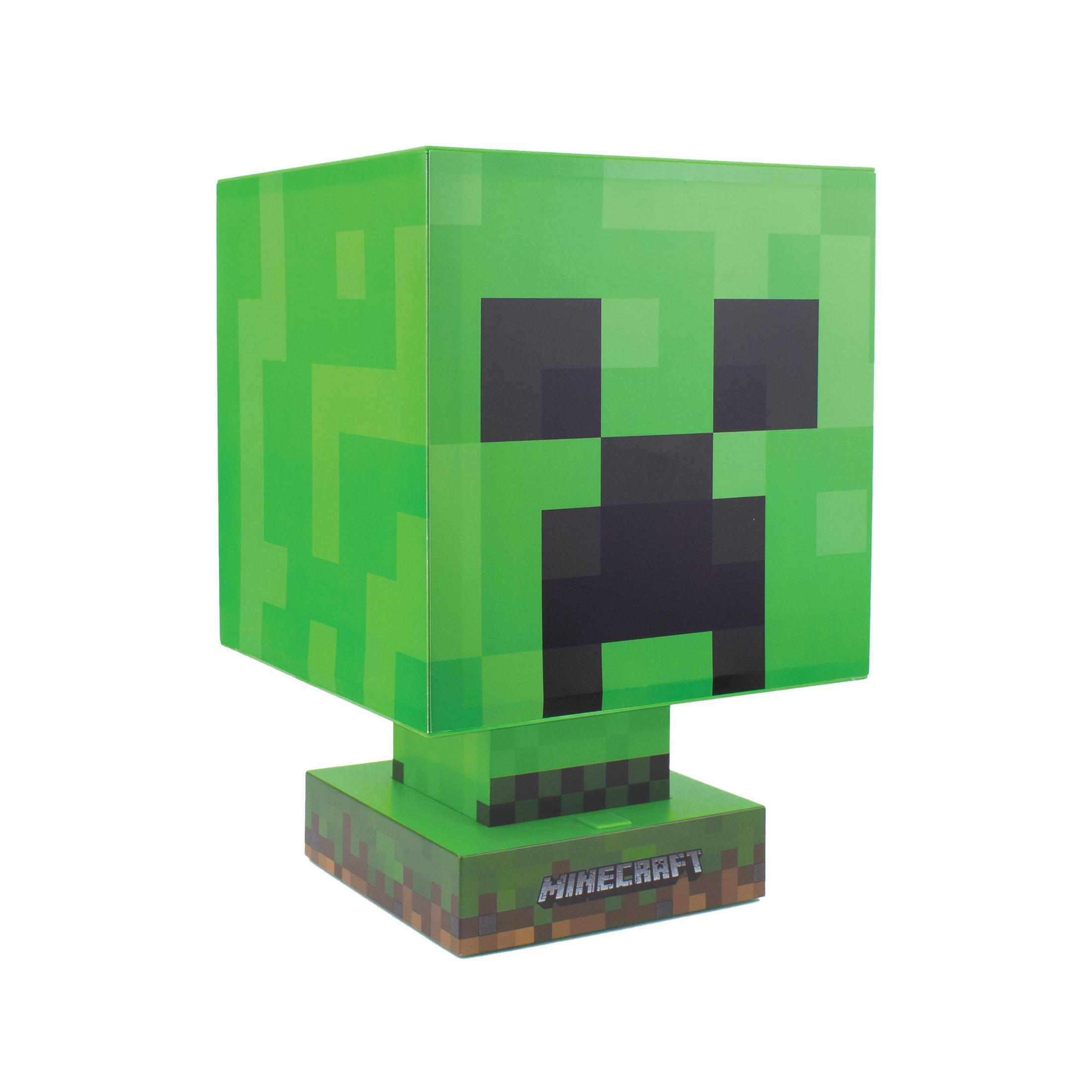 Zielona lampa z głową Creepera z Minecraft. Jest kwadratowa z czarnymi oczami i ustami. Jest na białej podstawie.