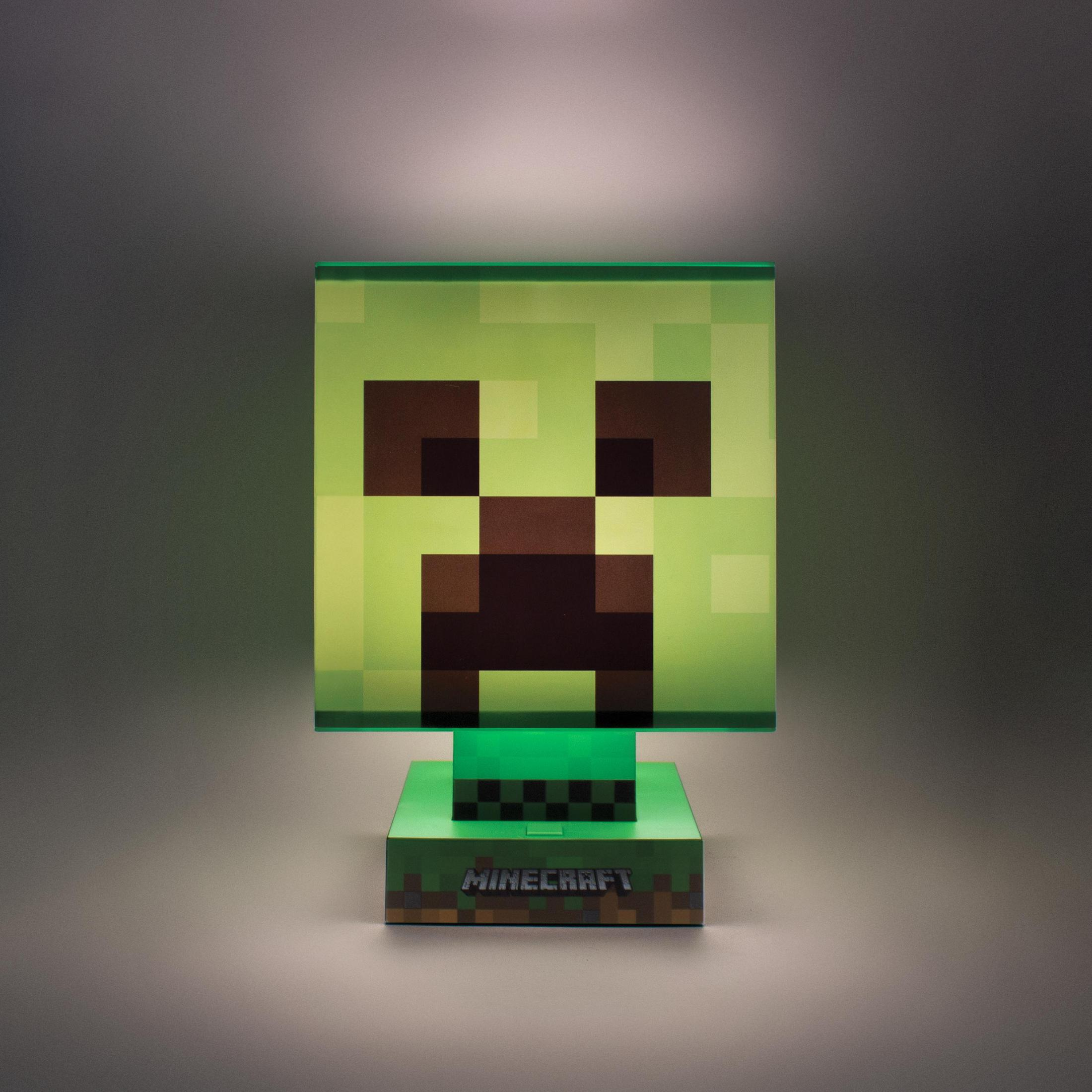 Zielona lampa z głową Creepera z Minecraft. Jest kwadratowa z czarną pikselową twarzą i zieloną podstawą.