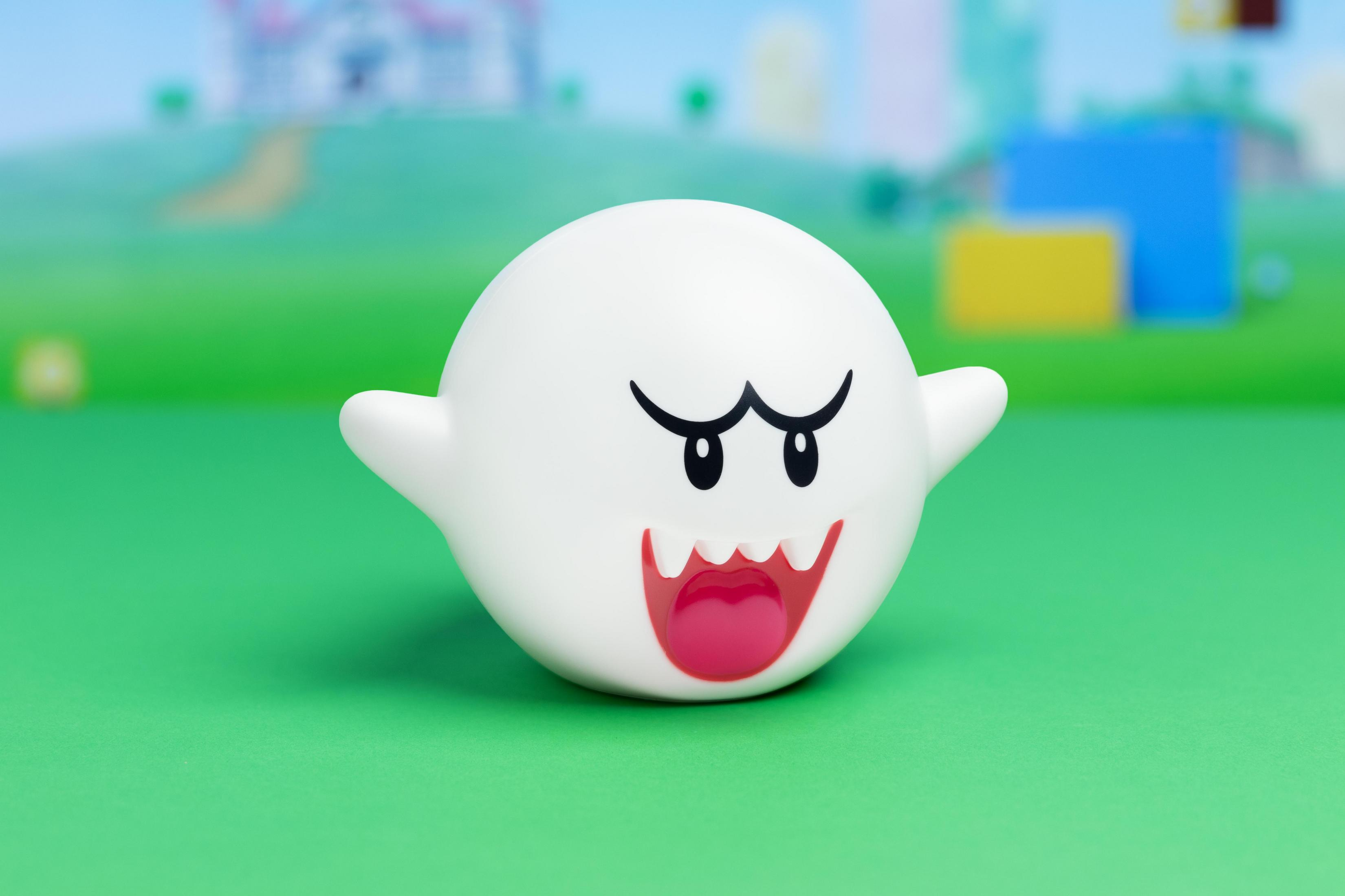 Ein weißer Boo-Charakter mit roter Zunge und schwarzen Augen in einer Cartoon-Umgebung.