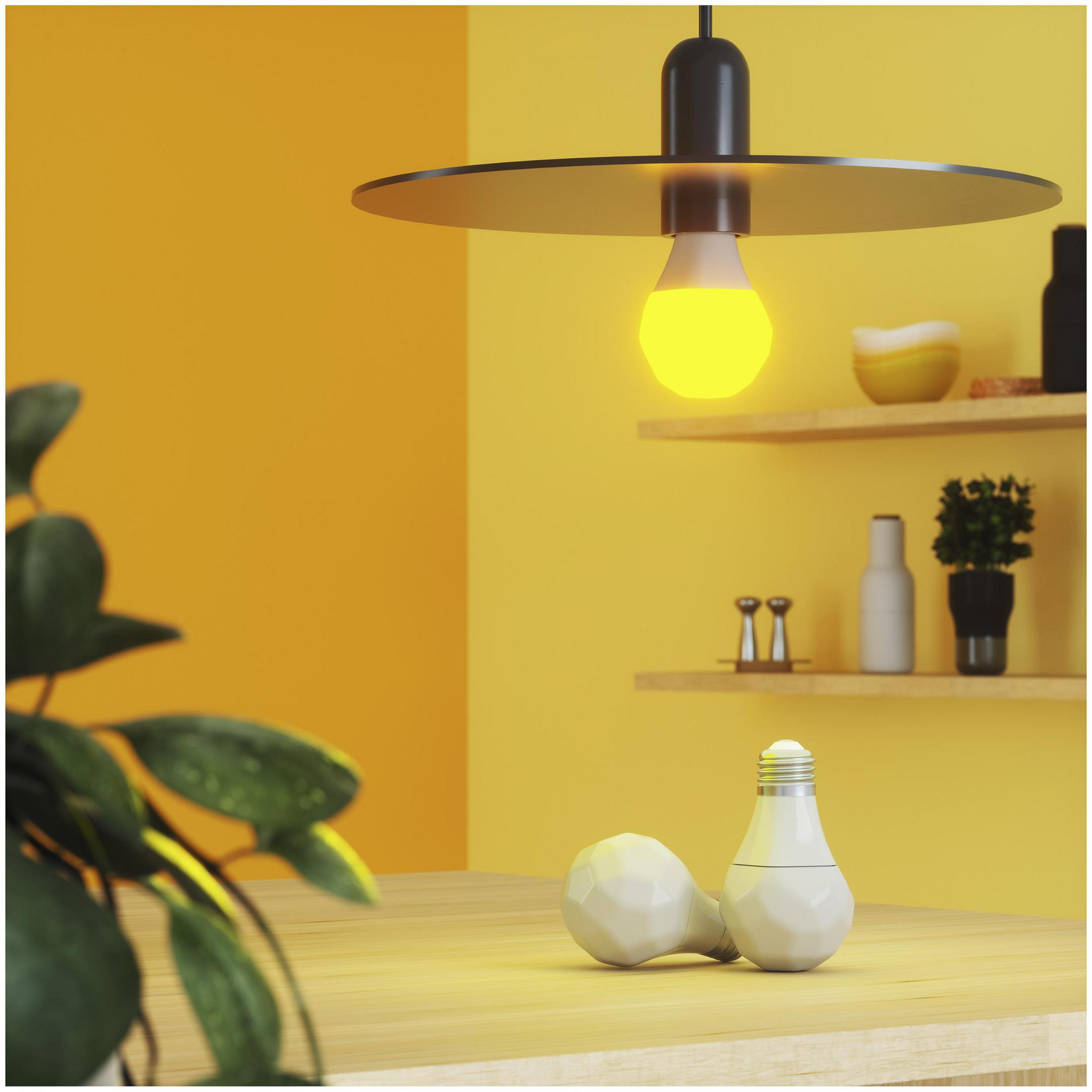 Una scena di cucina moderna con pareti gialle e un tavolo di legno. Una lampada e due lampadine sono sul tavolo.