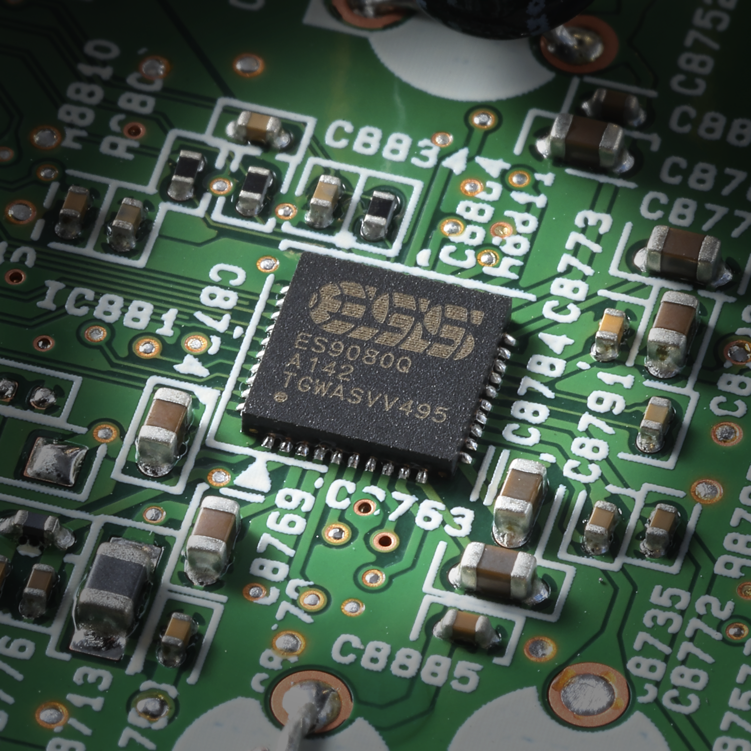 Nahaufnahme einer grünen Leiterplatte mit elektronischen Komponenten und einem Chip.