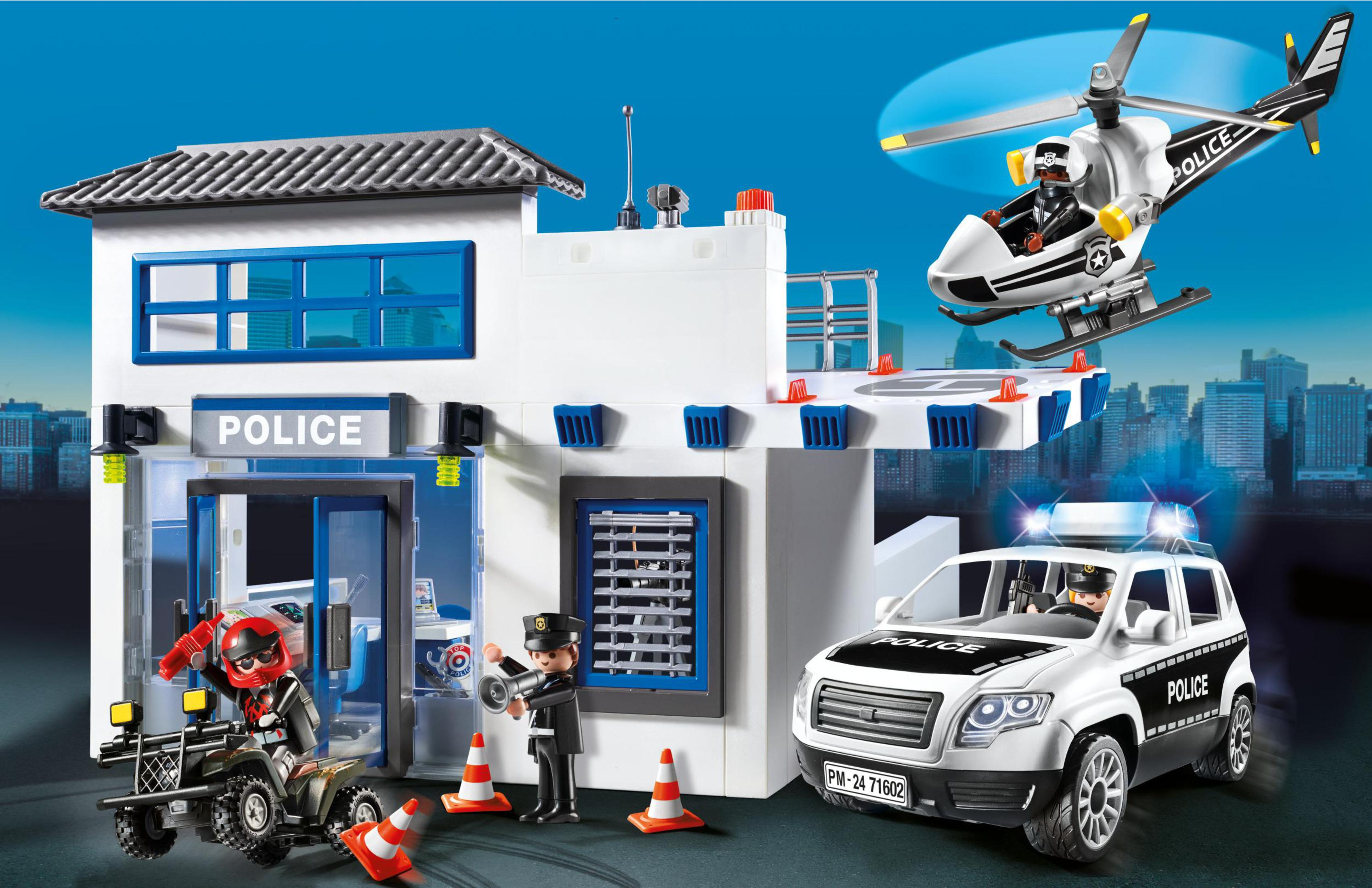 Scena della stazione di polizia Playmobil con figure, veicoli e elicottero.