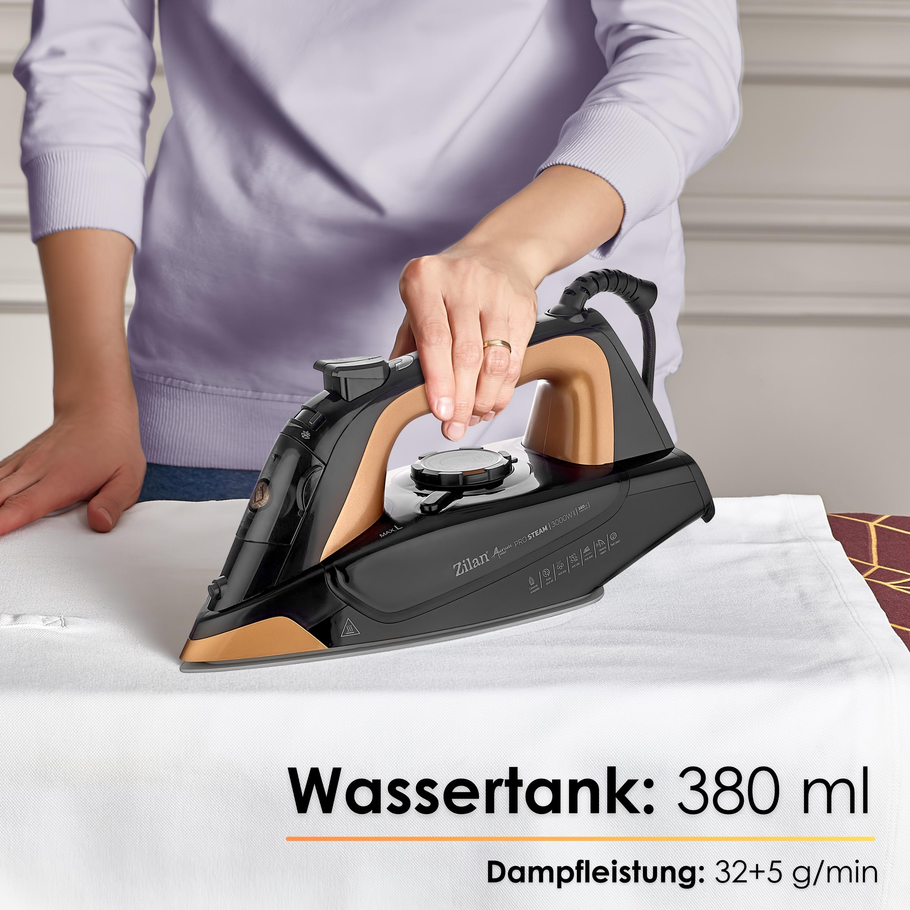 Eine Person bügelt weißen Stoff mit einem schwarzen und bronzefarbenen Bügeleisen.