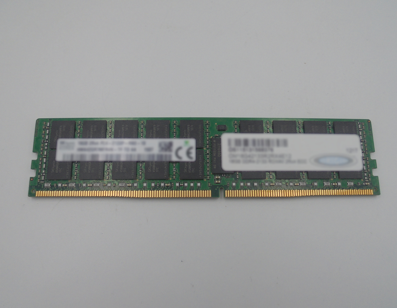 Un modulo di memoria RAM con connettori dorati, circuito stampato verde ed etichetta bianca.