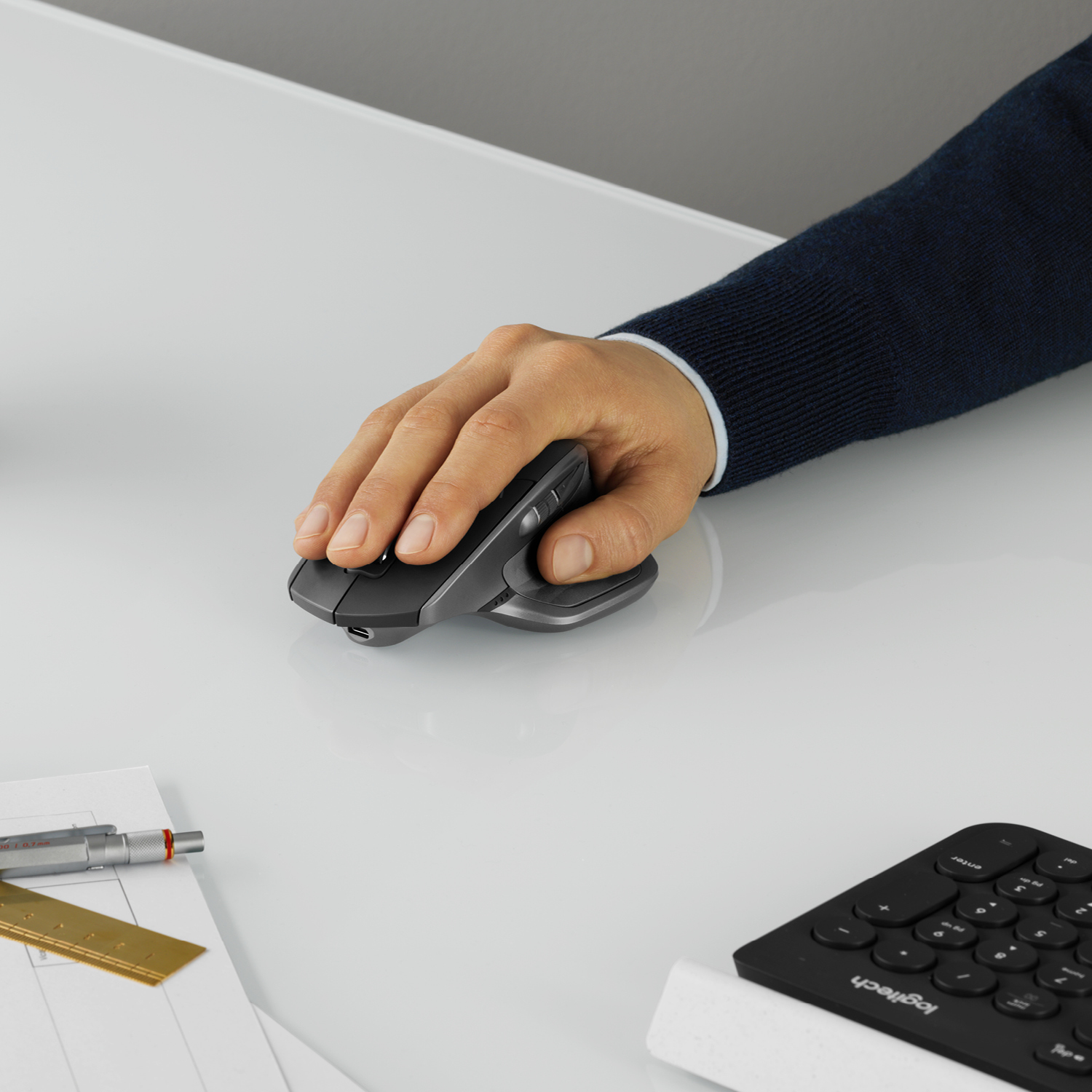 Hand van persoon op verticale muis op een witte tafel.