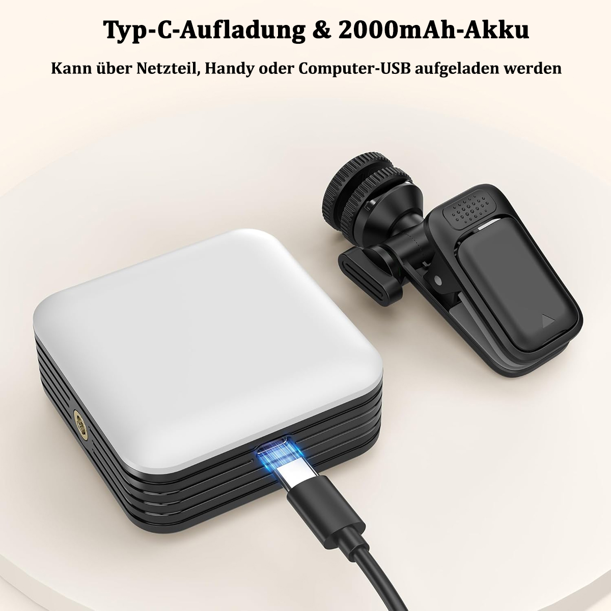 Weißes und schwarzes Gerät, das mit einem USB-C-Kabel aufgeladen wird, in der Nähe eines Clips.
