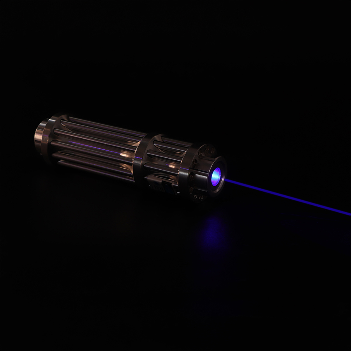 Schwarze Taschenlampe mit blauem Laserstrahl auf schwarzem Hintergrund. Das Licht kommt von vorne.