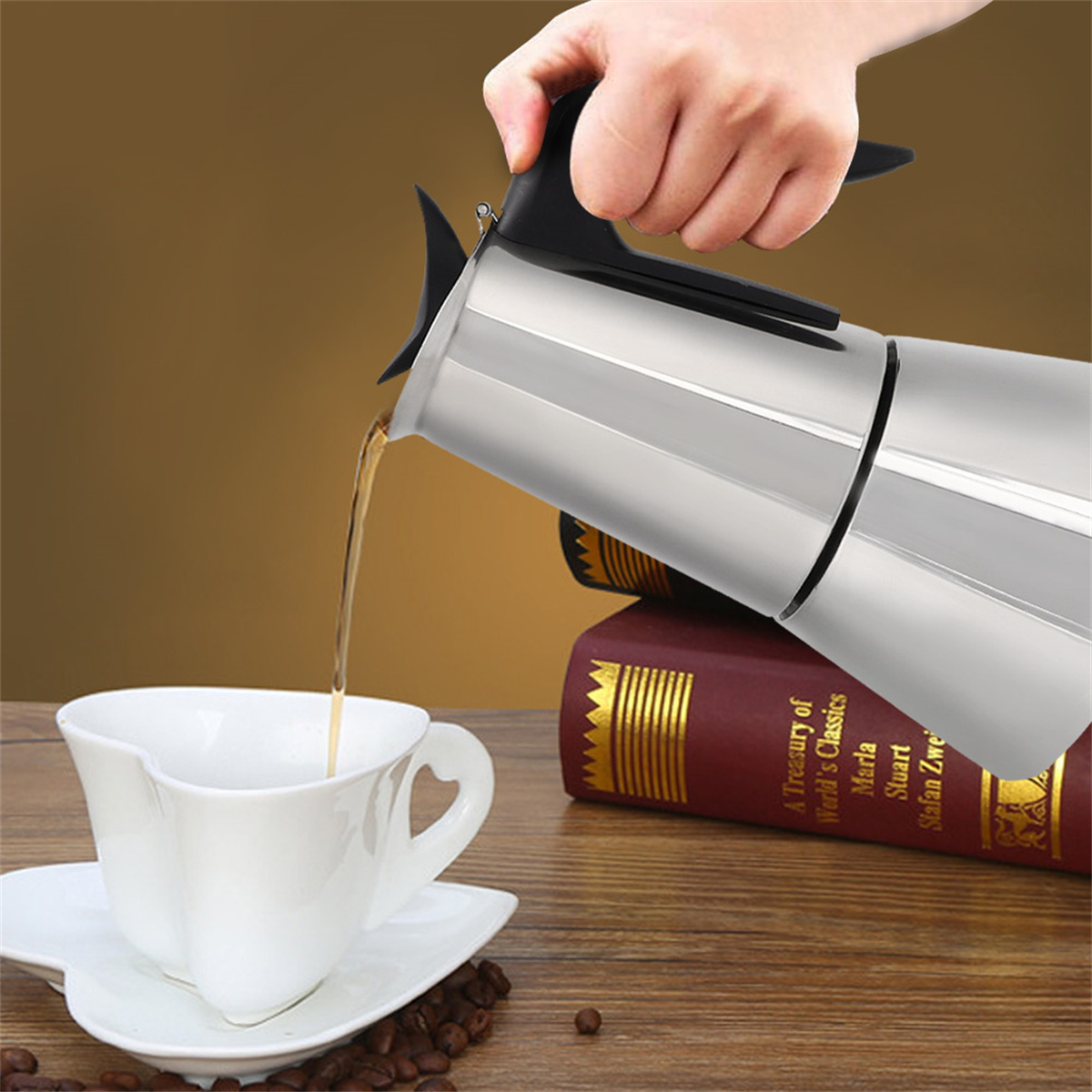 Person gießt Kaffee aus einer silbernen Kanne in eine weiße Tasse.