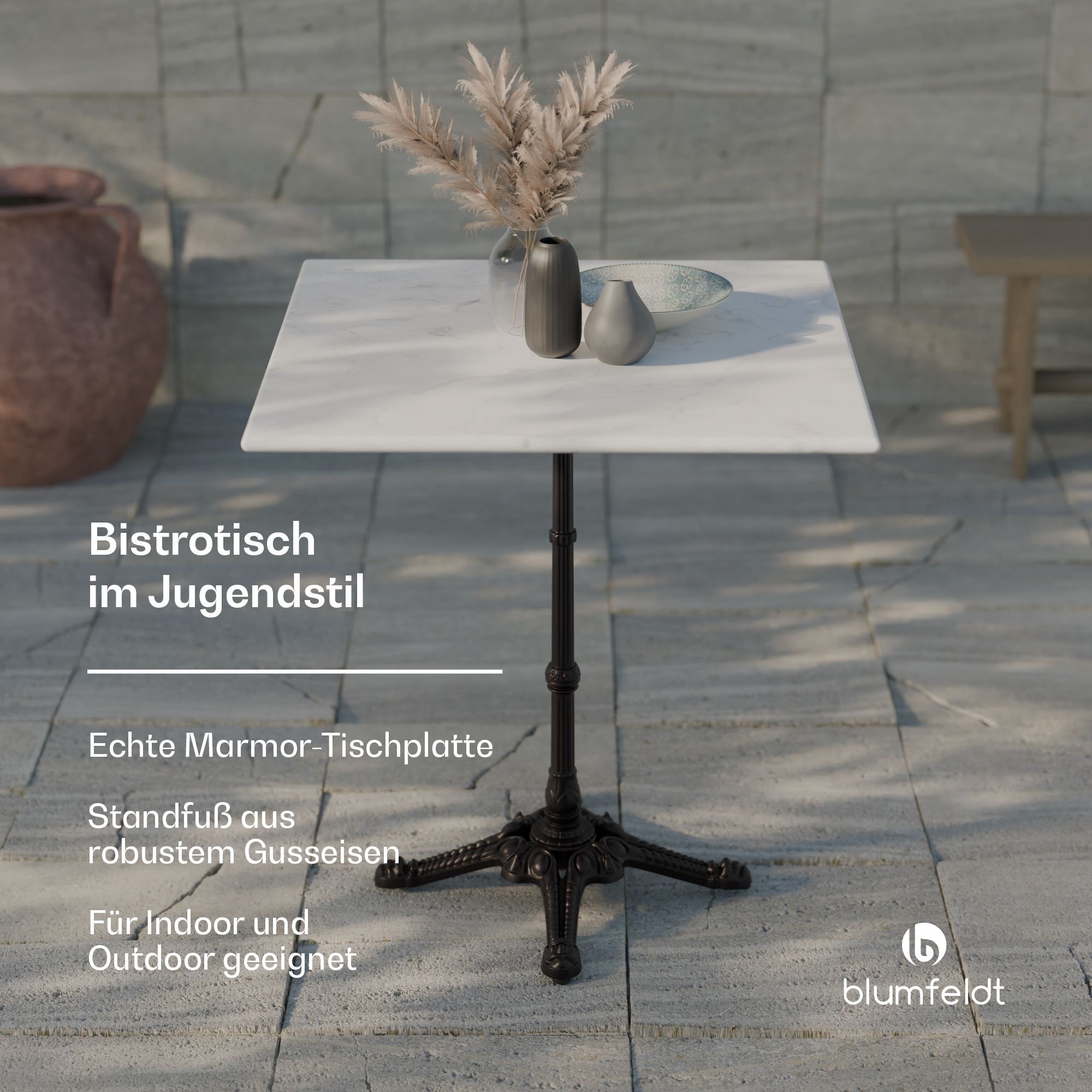 Quadratischer weißer Tisch mit schwarzem Bein. Dekorative Vase mit Blumen, Hintergrund Steinmauer.
