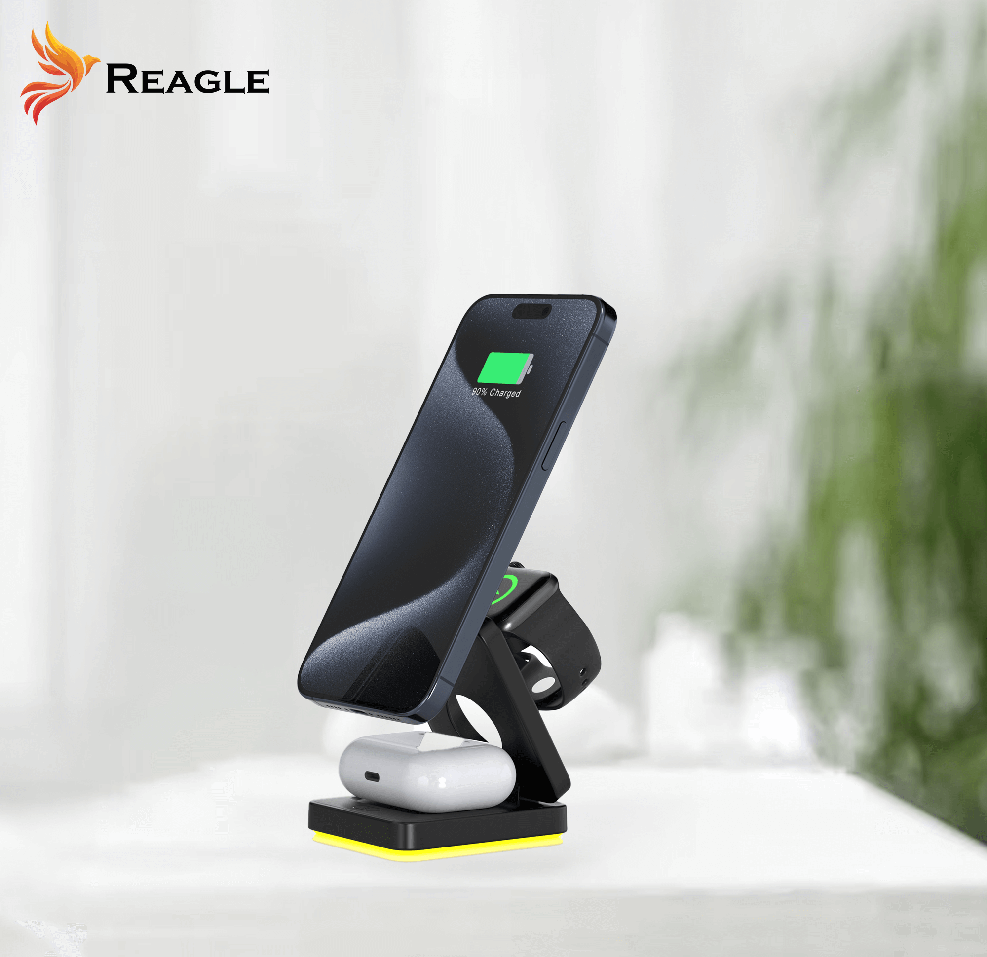 Telefon, zegarek i słuchawki ładujące się na stojaku. Białe tło, logo Reagle.