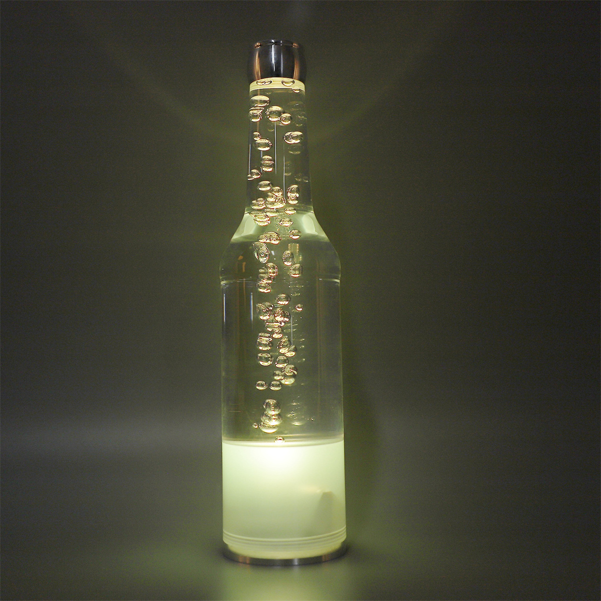 Eine dekorative, flaschenförmige Lampe mit Blasen im Inneren und hellem Licht am Boden.