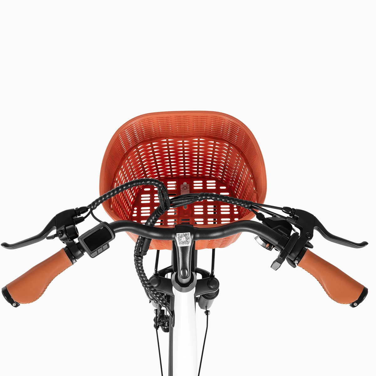 Kierownica roweru z pomarańczowym koszykiem. Skórzane uchwyty na kierownicy. Białe tło.