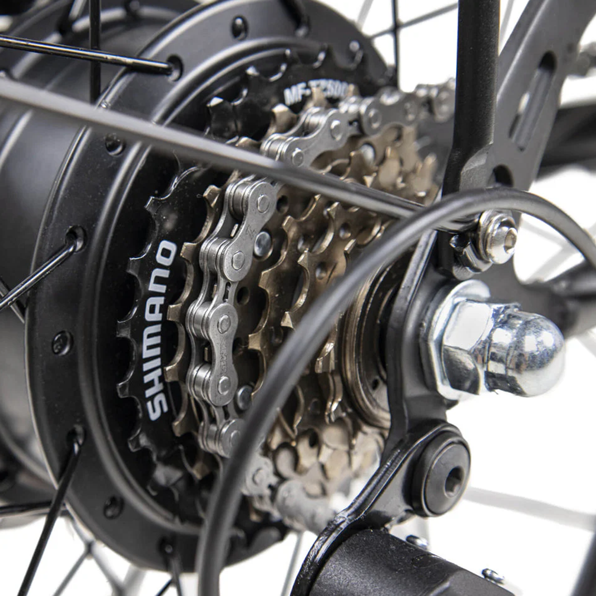 Zbliżenie na łańcuch i zębatki roweru. Widoczna marka Shimano. Łańcuch jest metaliczny srebrny.