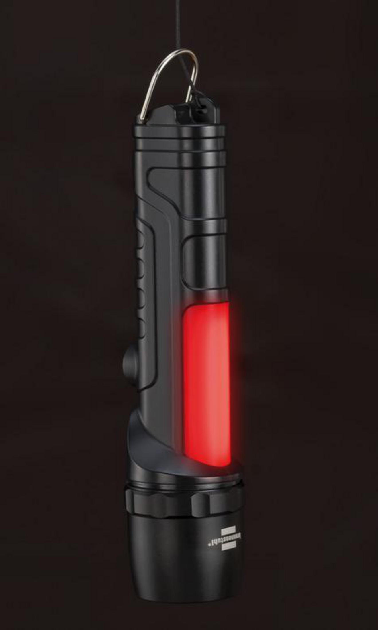 Czarna latarka z podświetlanym czerwonym fragmentem, wisząca na czarnym tle.
