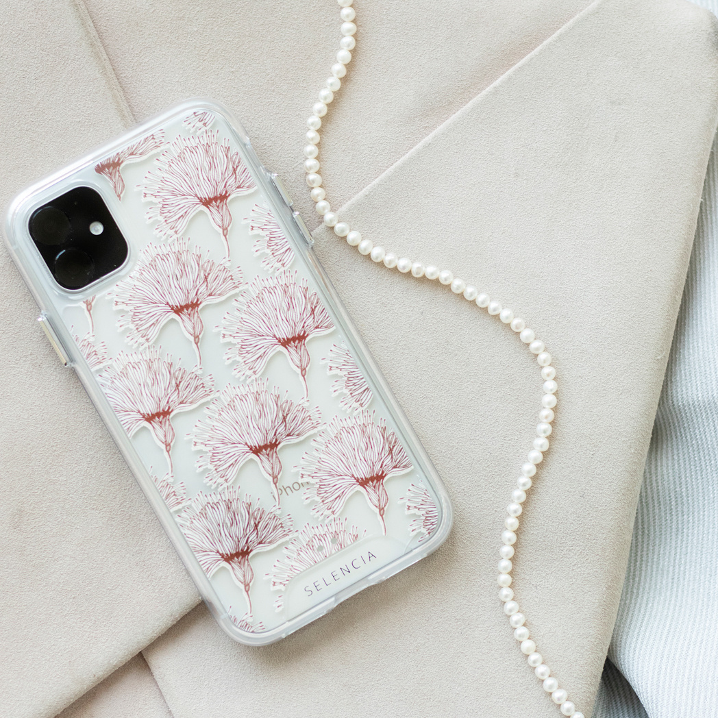 Coque transparente avec motif de fleurs roses. Perles et fond de blazer blanc.