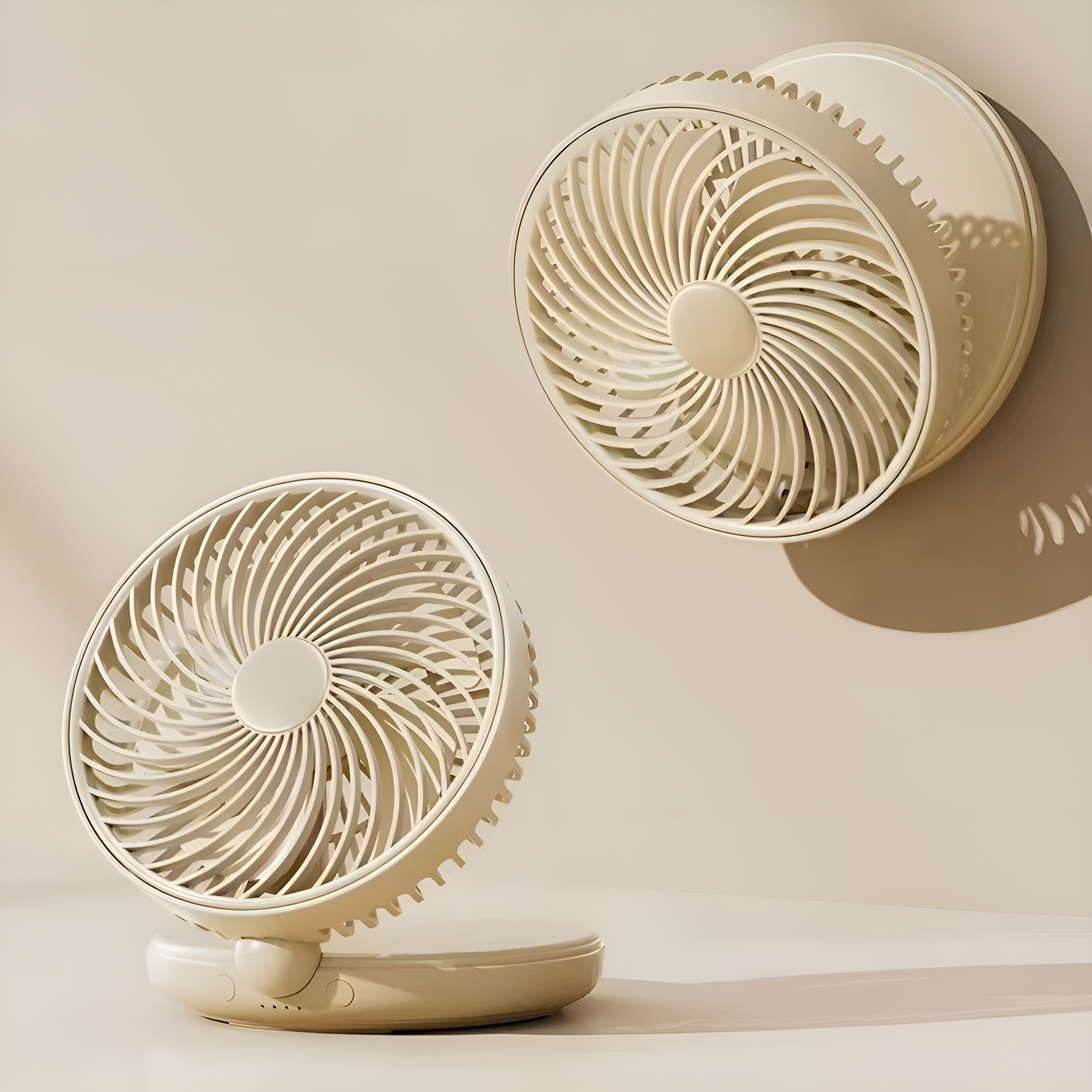 Zwei beige Ventilatoren, einer auf einem Ständer, der andere an der Wand hängend, beide mit spiralförmigen Blättern.
