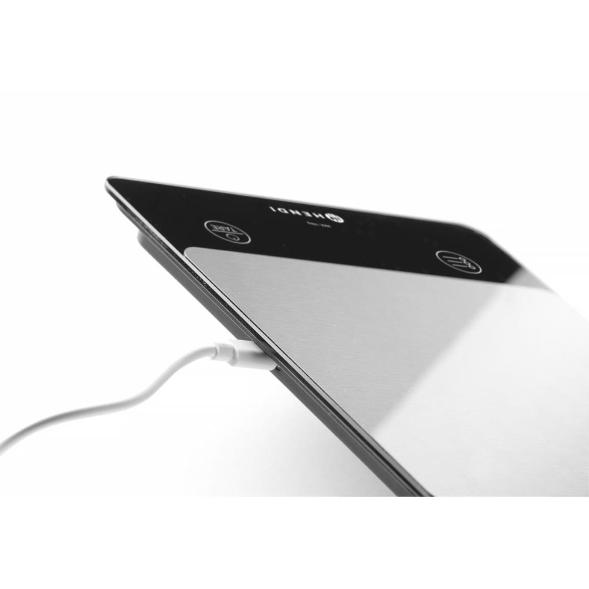 Eine digitale Küchenwaage mit eingestecktem Ladekabel wird gezeigt.