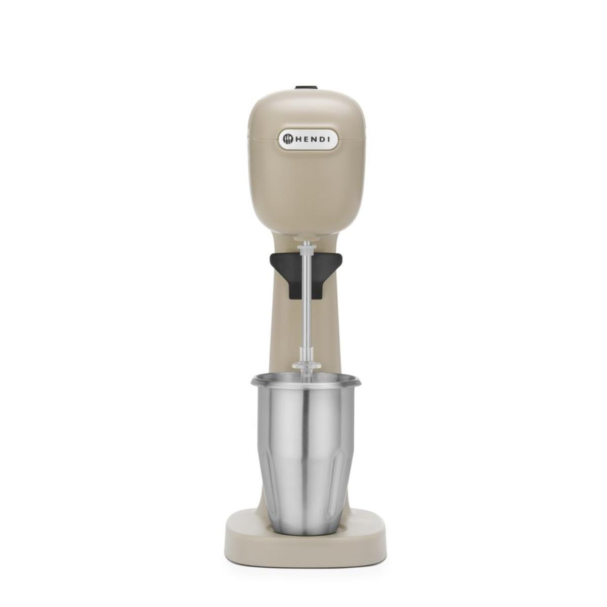 Macchina per milkshake beige con una tazza di metallo e una base. Sfondo bianco.