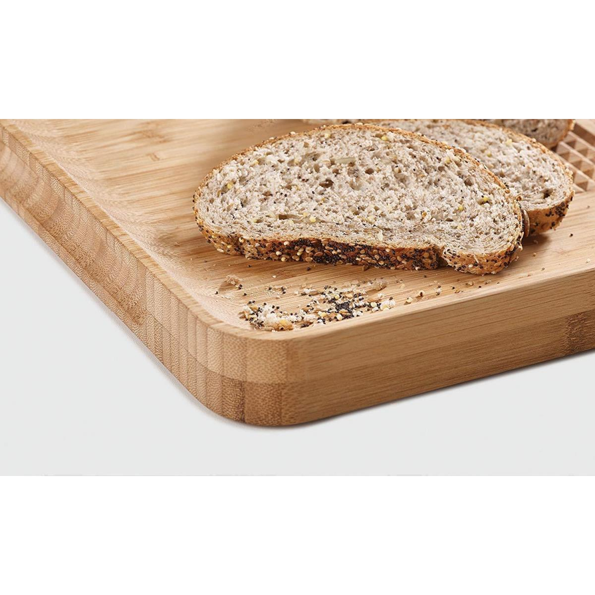 Zwei Brotscheiben auf einem Holzschneidebrett mit Krümeln.