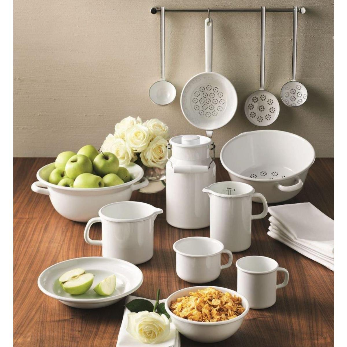 Weißes Küchengeschirr-Set. Weiße Schüsseln, Krüge und Utensilien. Äpfel und Blumen sind im Bild.