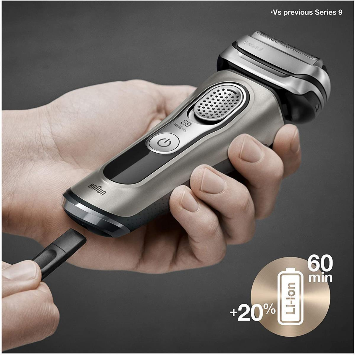 Uomo che tiene un rasoio Braun Series 9 argentato, con un piccolo strumento di pulizia.