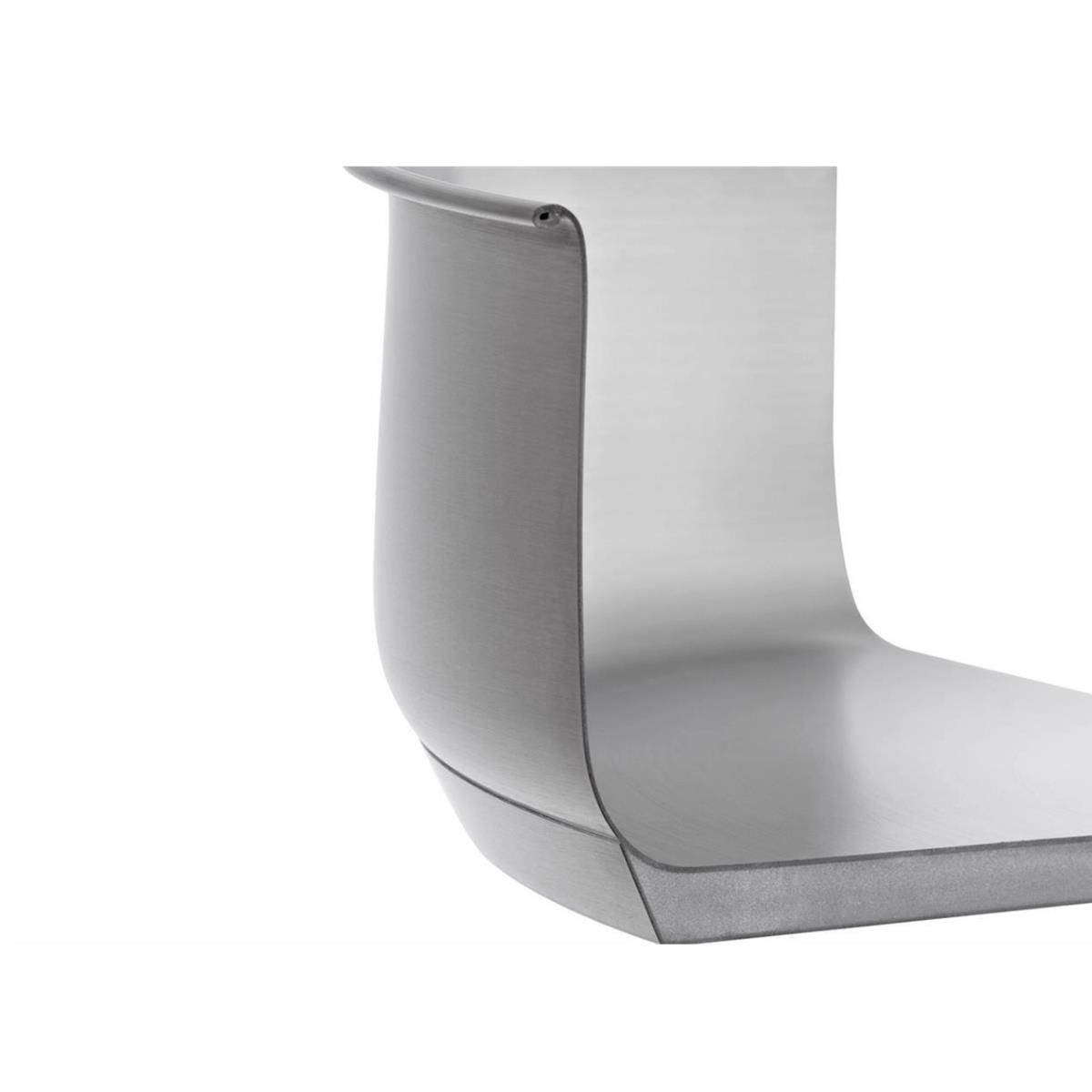 Zbliżenie zakrzywionego, srebrnego metalowego przedmiotu, prawdopodobnie części sprzętu kuchennego.