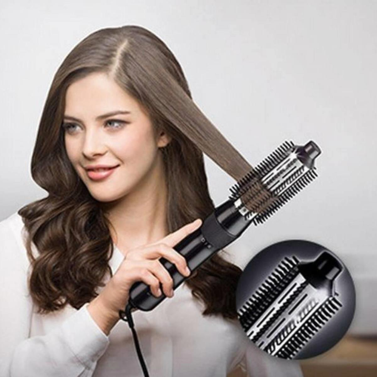 Kobieta stylizująca włosy suszarką w kształcie szczotki, mały obrazek szczegółów szczotki.