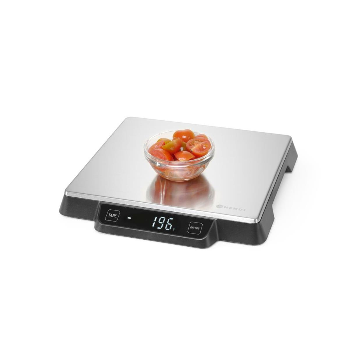 Waage mit Tomaten in einer Glasschüssel, auf weißem Hintergrund.