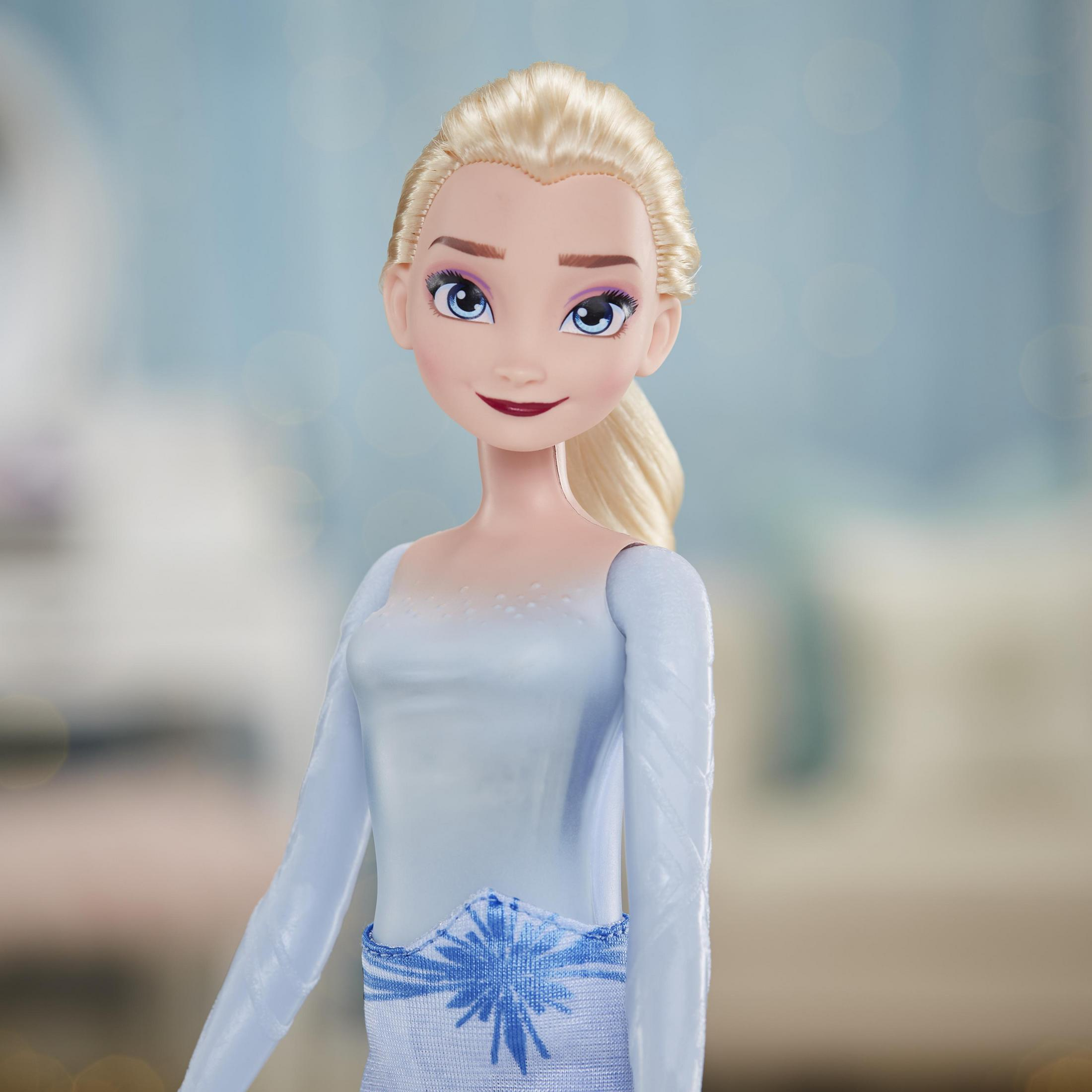 Nahaufnahme einer Elsa-Puppe mit blonden Haaren, blauen Augen und einem hellblauen Kleid, die in die Kamera blickt.