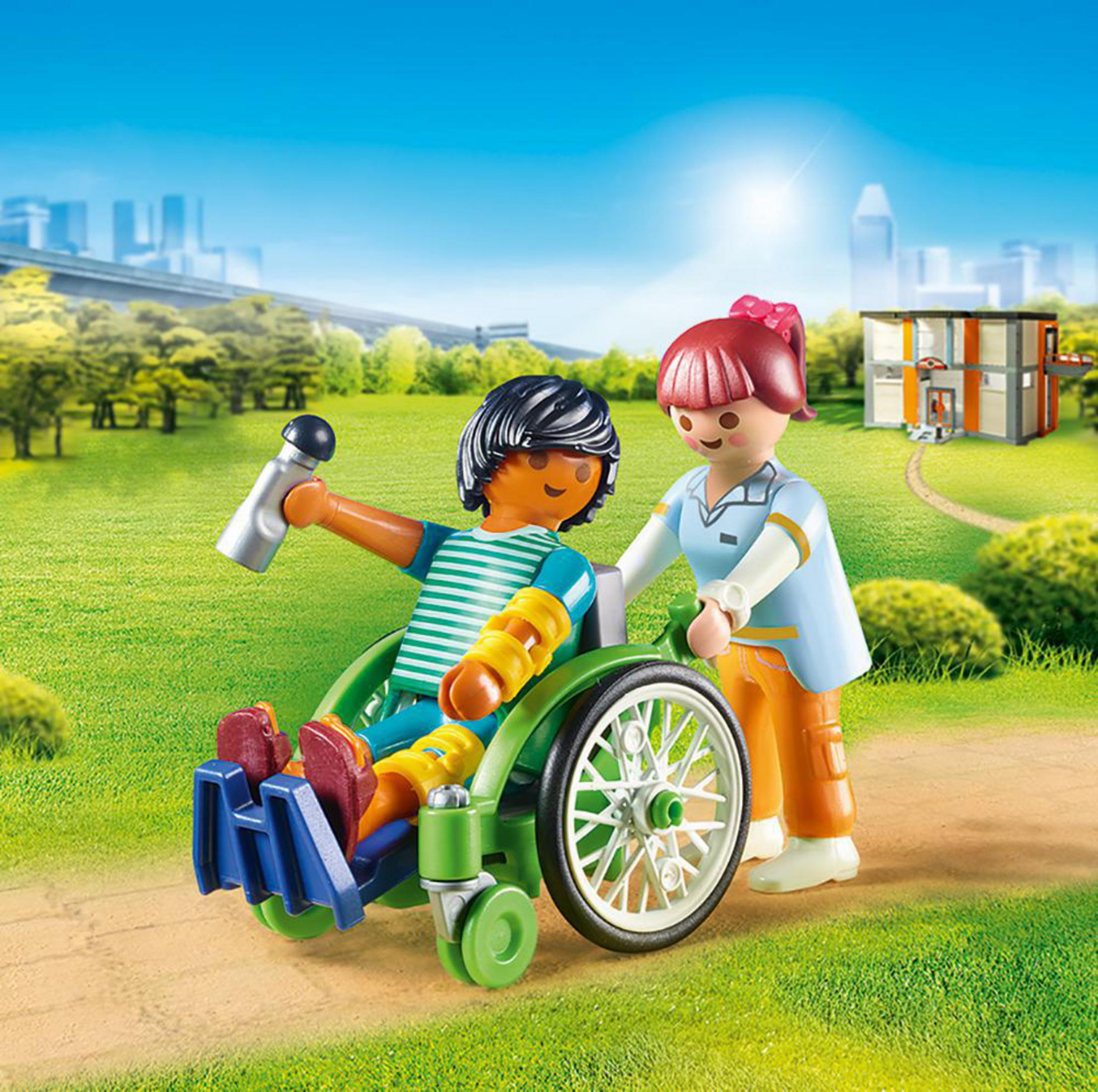 Personnages Playmobil : personne en fauteuil roulant et soignant sur chemin vert.