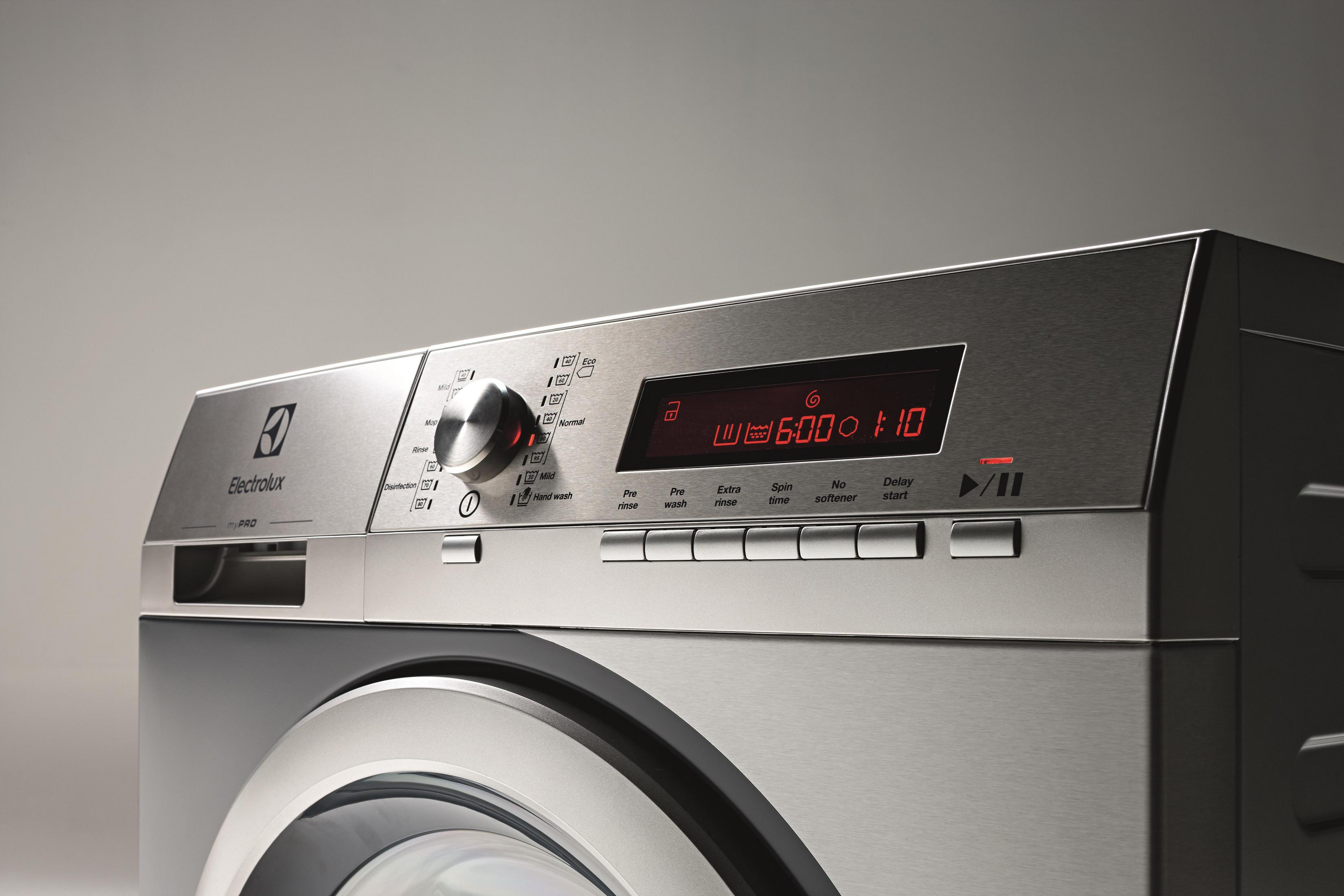 Detail des Waschmaschinen-Bedienfelds mit Knöpfen und einer Digitalanzeige, die die Zeit anzeigt.