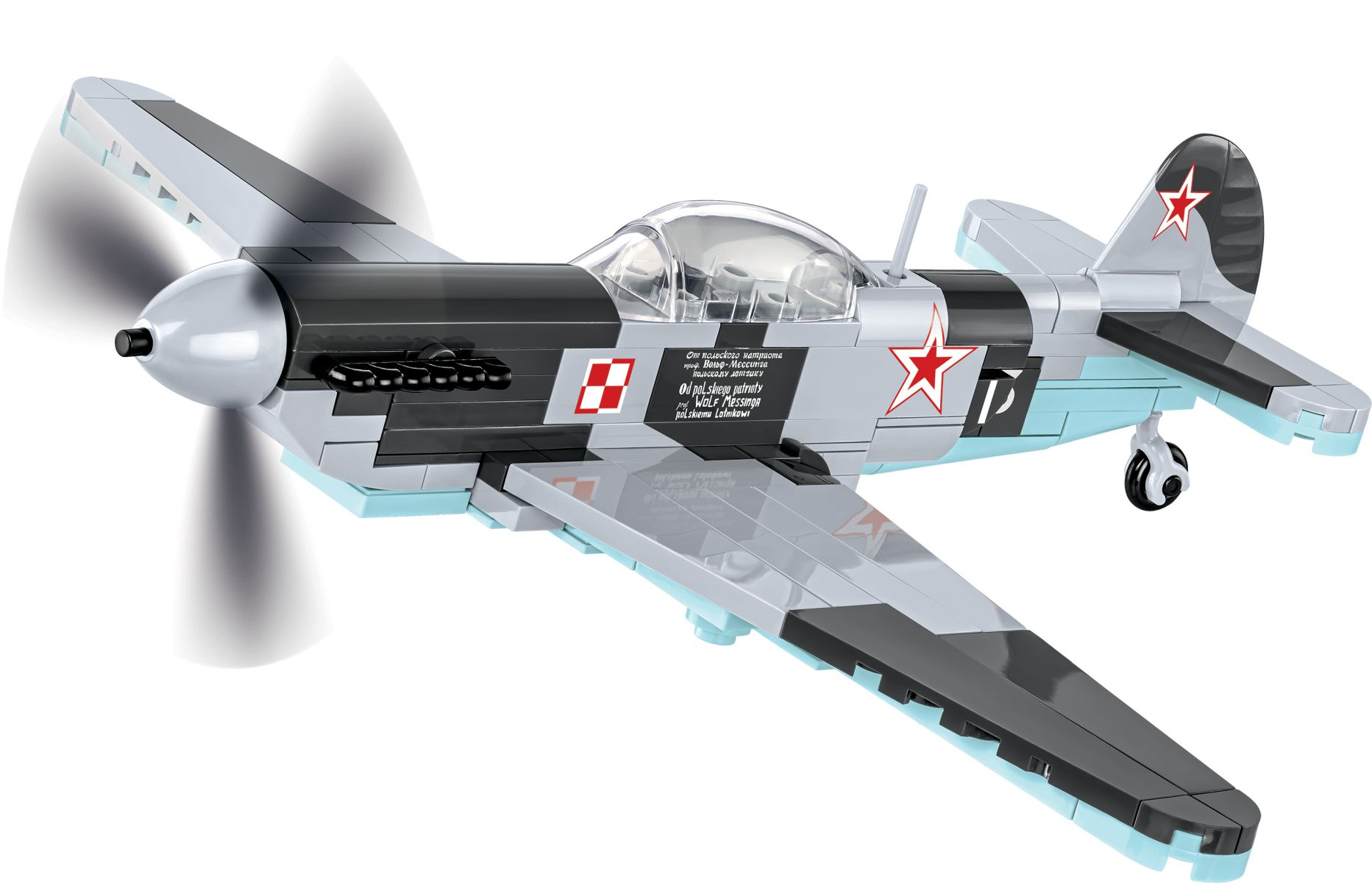 Model samolotu ze śmigłem, w locie. Samolot jest pomalowany na szaro i jasnoniebiesko.