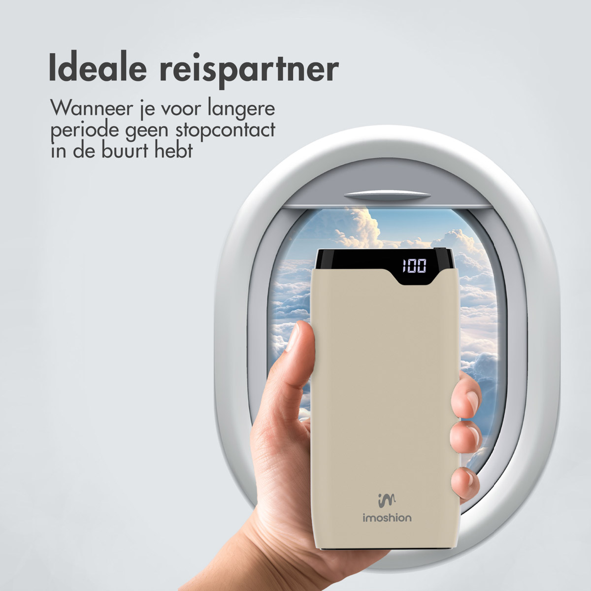 Une main tenant une batterie externe beige, visible à l'intérieur d'un hublot d'avion.