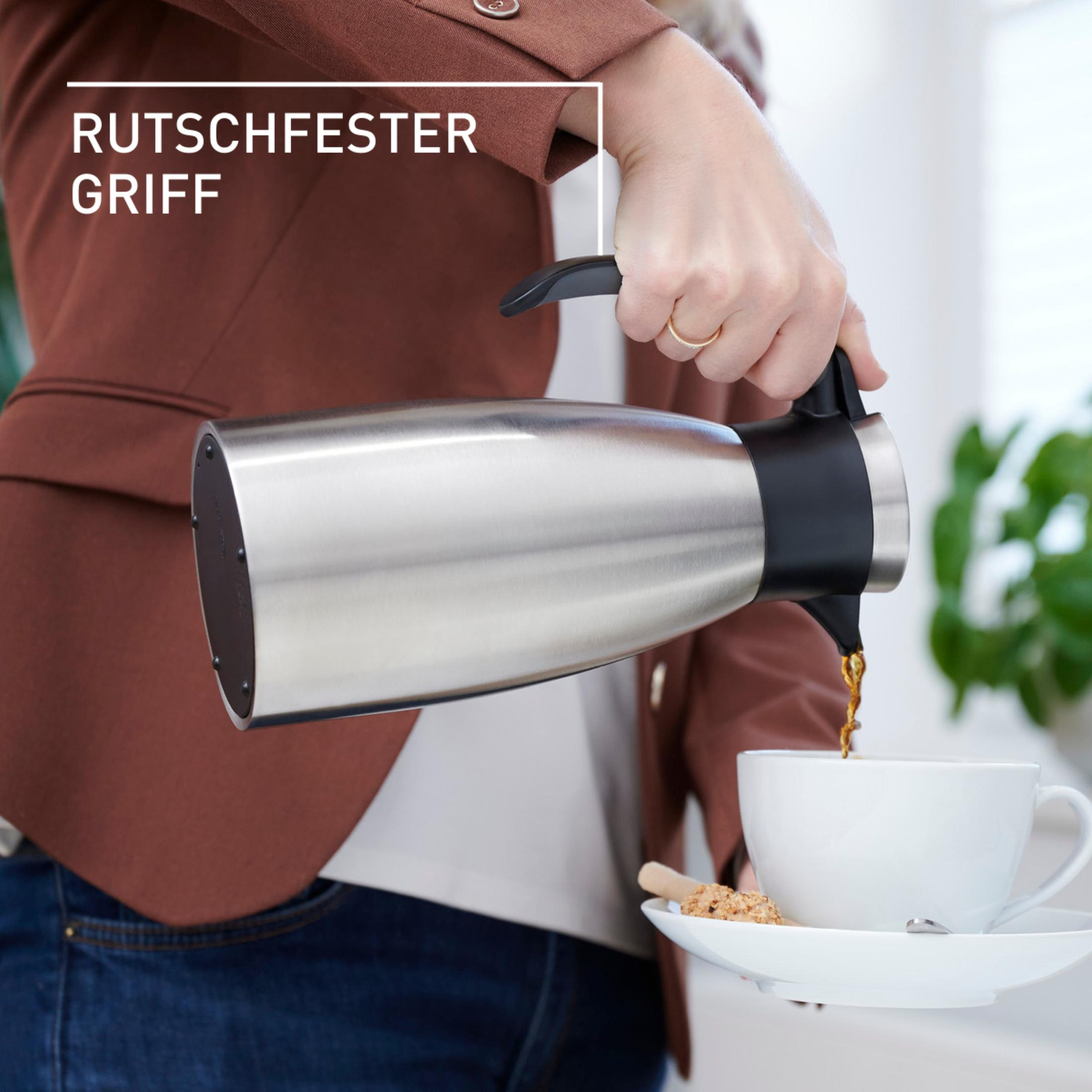 Une personne verse du café d'une carafe argentée dans une tasse blanche sur une soucoupe.