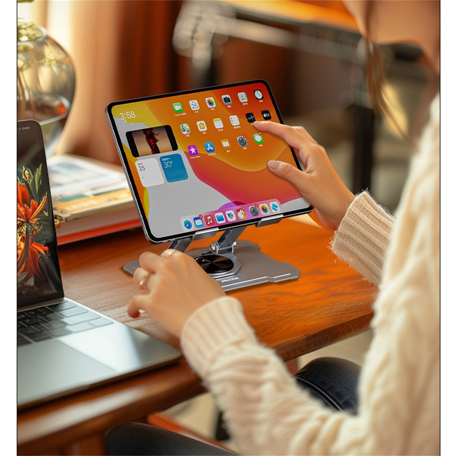 Frau benutzt Tablet auf einem Ständer am Tisch.
