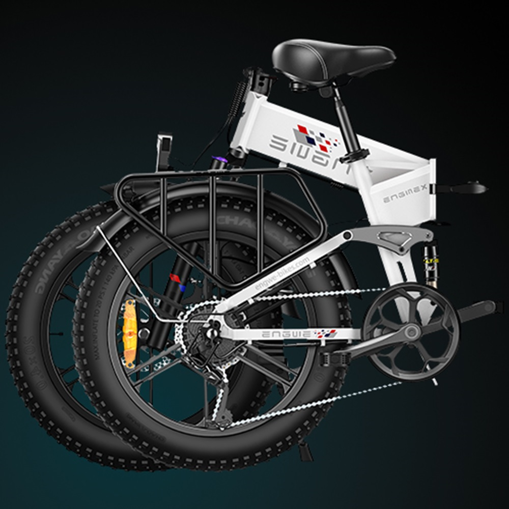 Una bicicleta plegable blanca con ruedas negras y una parrilla negra, sobre un fondo oscuro.