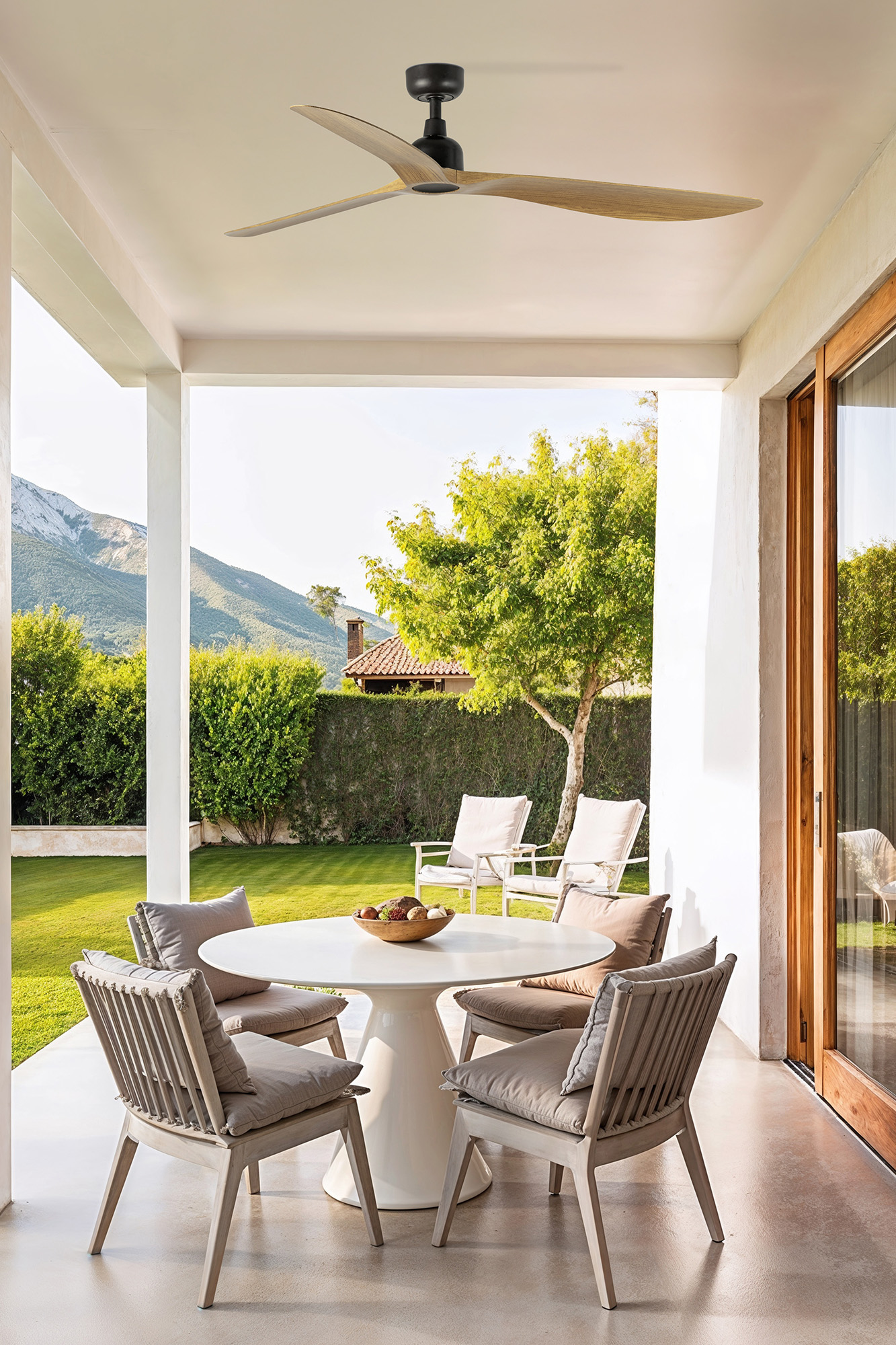 Terrasse mit Deckenventilator und Tisch mit Stühlen.