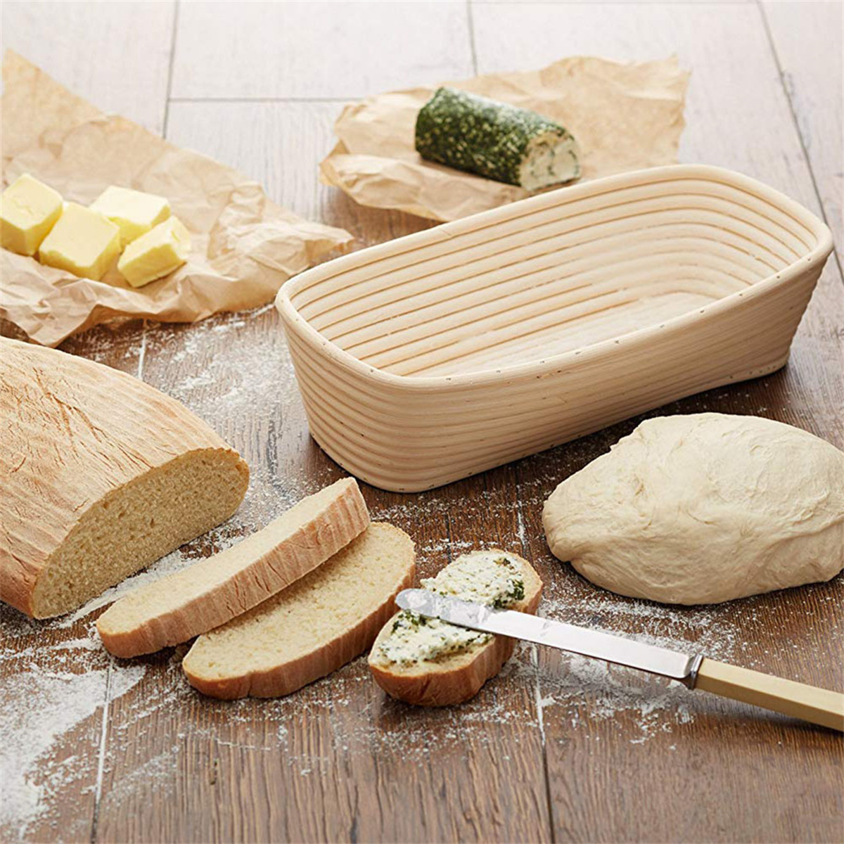 Szene der Brotherstellung. Geschnittenes Brot, Teig, Butter, Brotkorb und Käse auf Holzoberfläche.