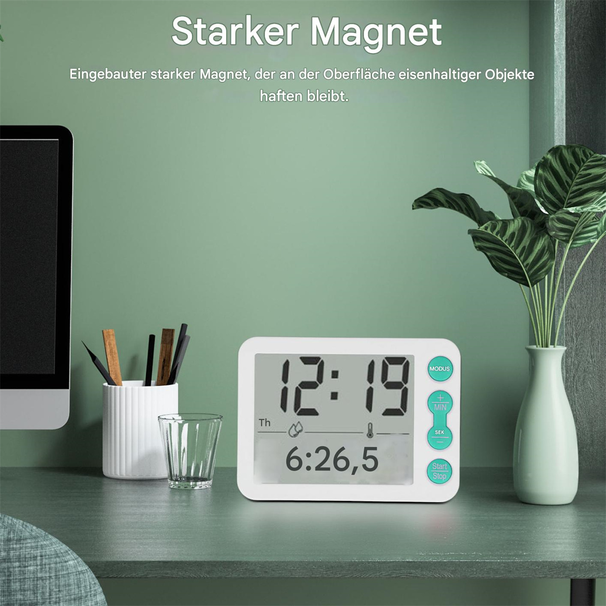 Weißer digitaler Timer mit Digitalanzeige und Knöpfen. Artikel liegen auf einem Holztisch.