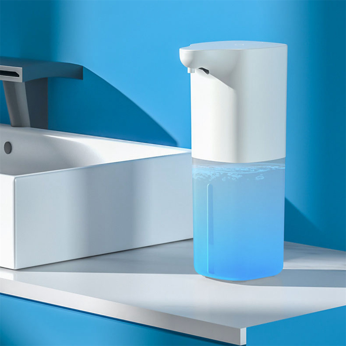 Weißer automatischer Seifenspender mit blauer Flüssigkeit. Weiße Oberfläche, blauer Hintergrund.