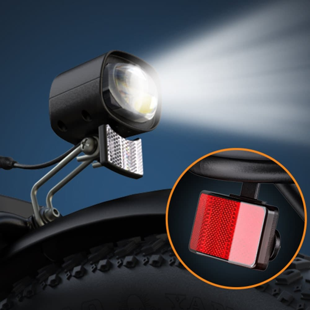 Primo piano di un faro per bici e un catarifrangente rosso su sfondo scuro.