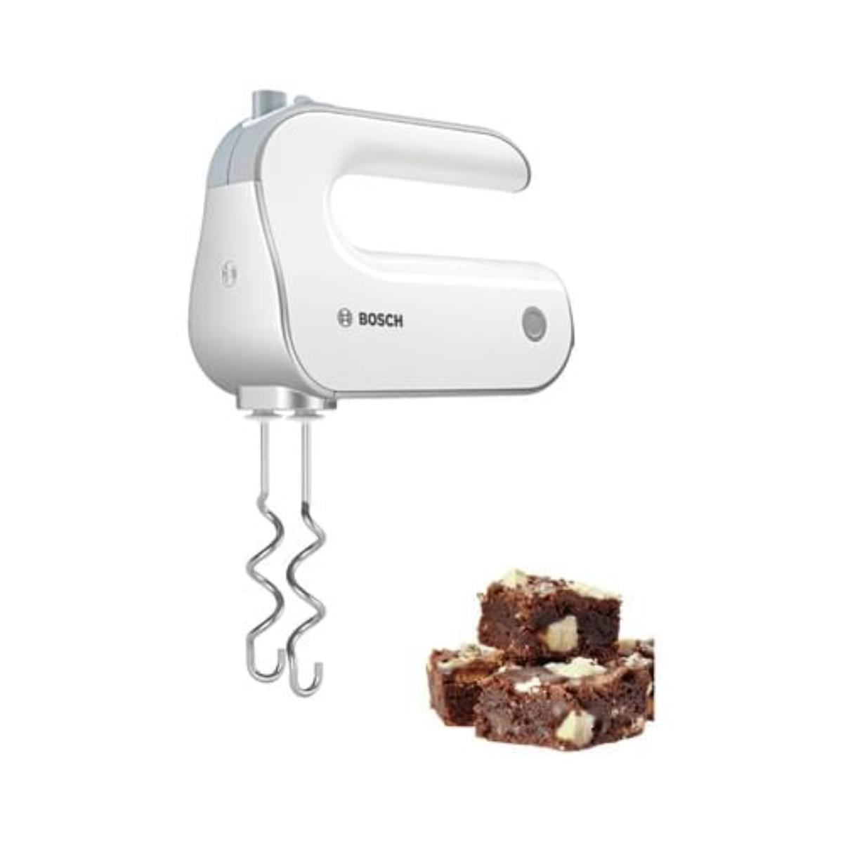 A white Bosch hand mixer with beaters, next to a stack of brownies with white chocolate chips.