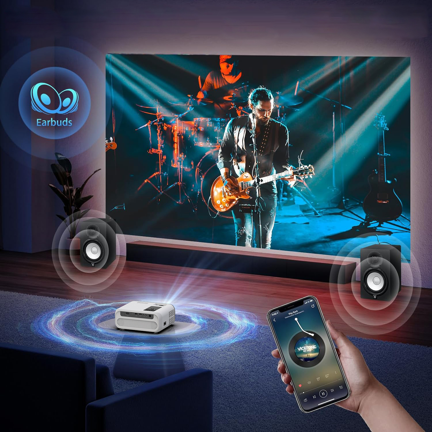 Osoba gra na gitarze na scenie, a telefon wyświetla elementy sterowania muzyką. Głośniki flankują projektor wyświetlający ekran.