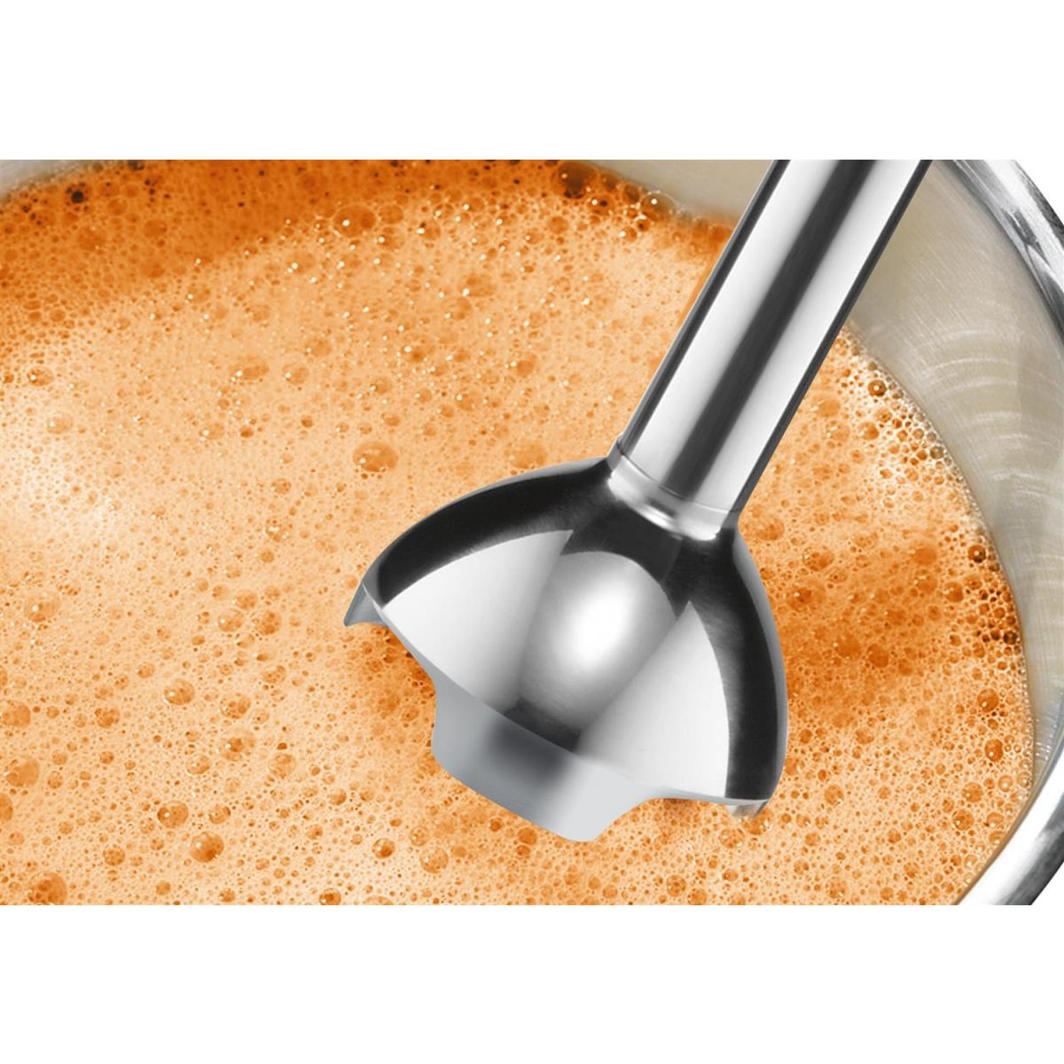 Nahaufnahme eines silbernen Stabmixer-Kopfes in einer schaumigen, orangefarbenen Flüssigkeit.